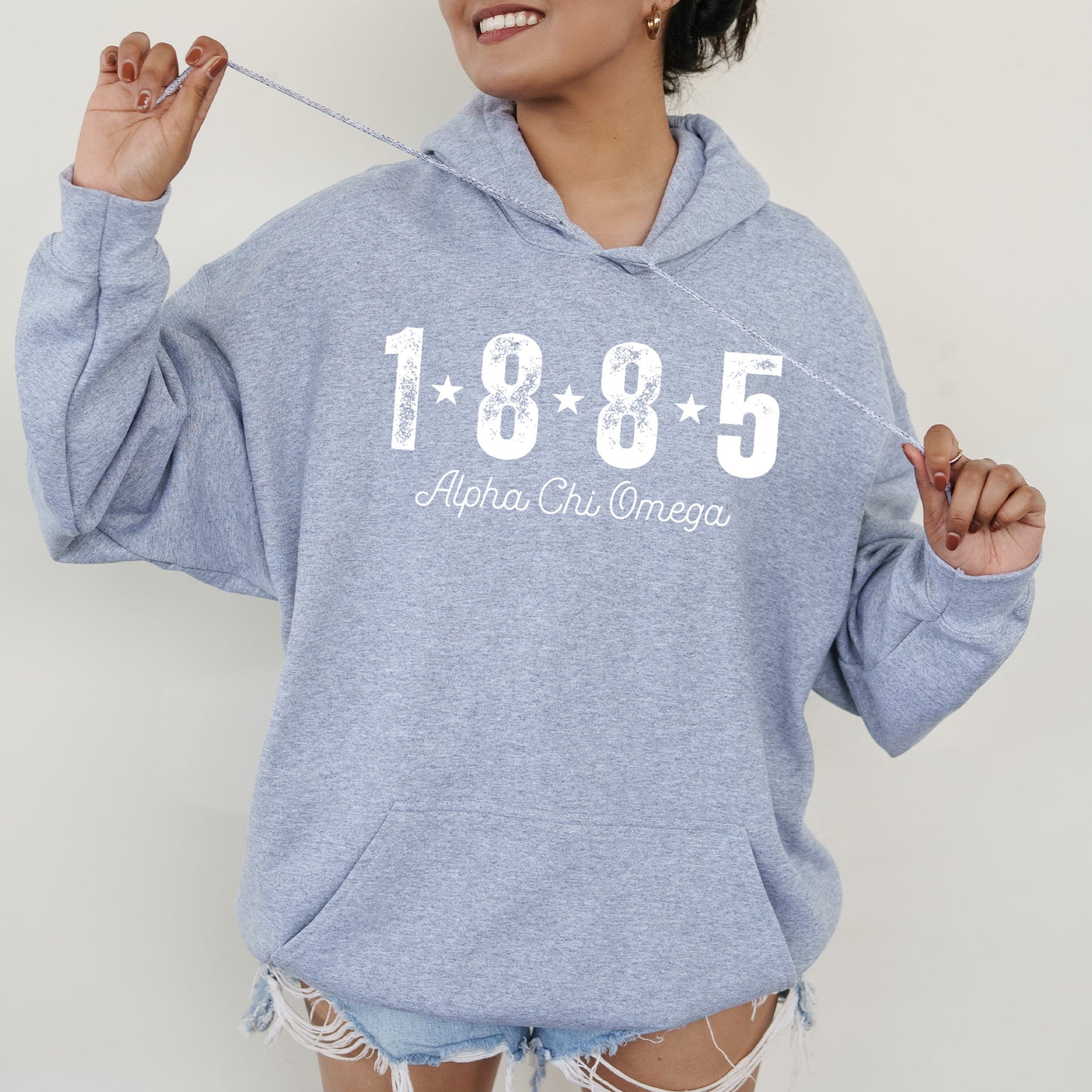 a woman in a blue hoodie is holding a toothbrush