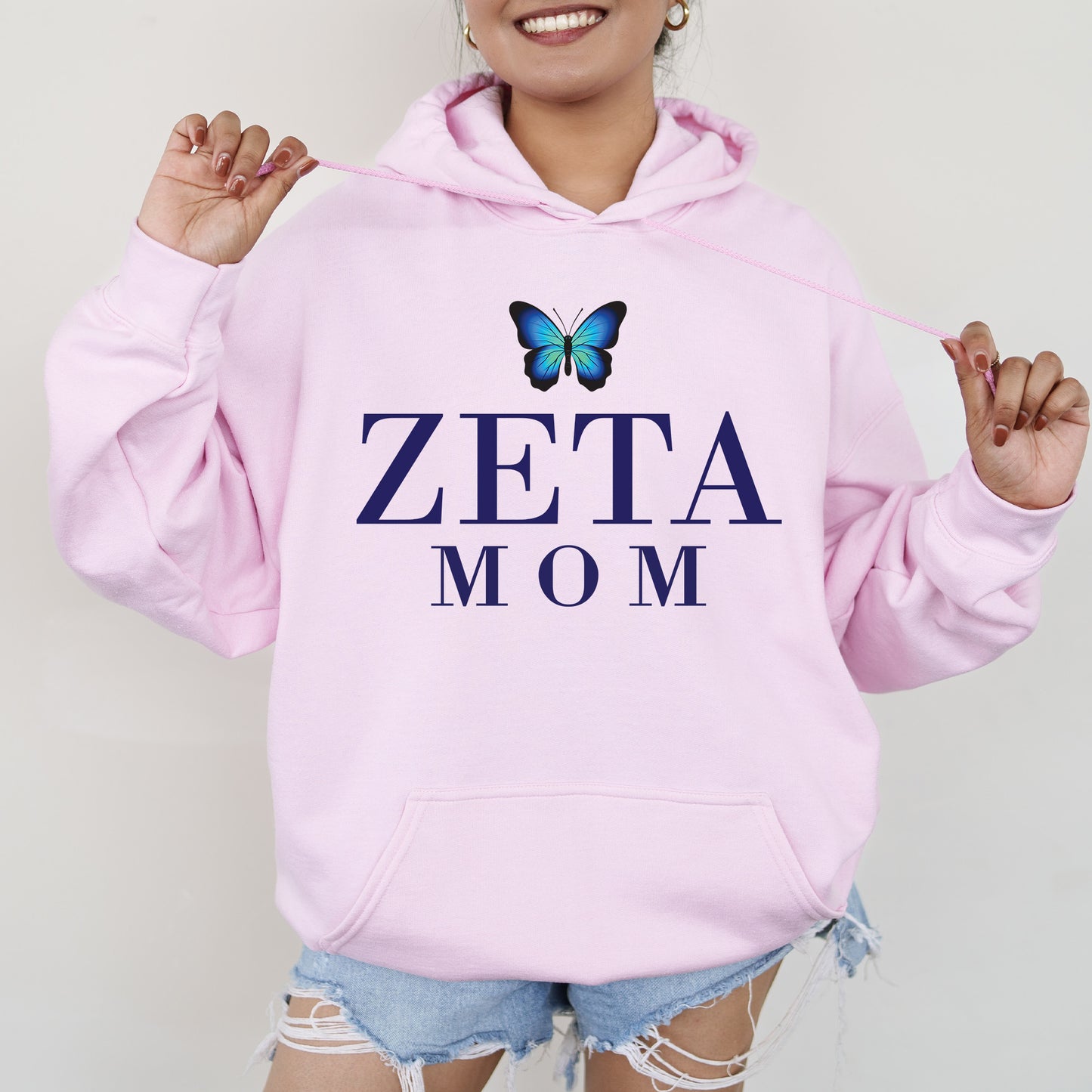 a woman wearing a pink hoodie with a butterfly on it