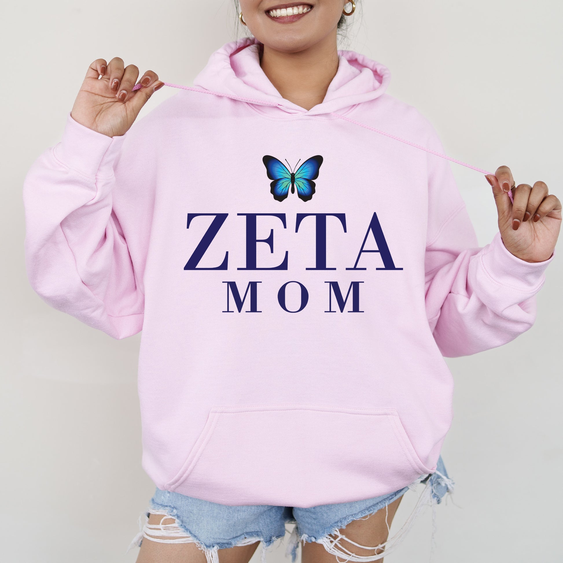 a woman wearing a pink hoodie with a butterfly on it