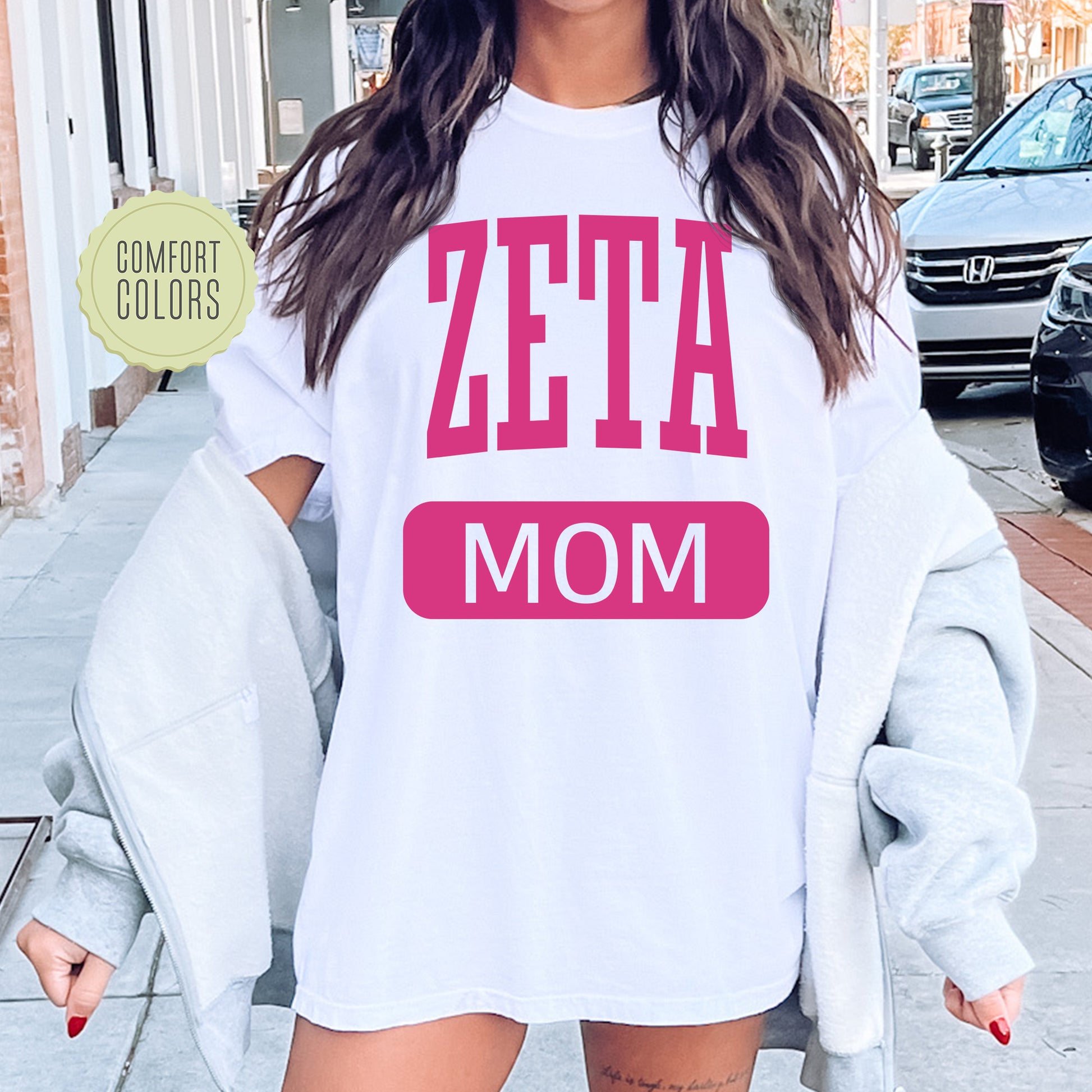 a woman wearing a white shirt that says zeta mom