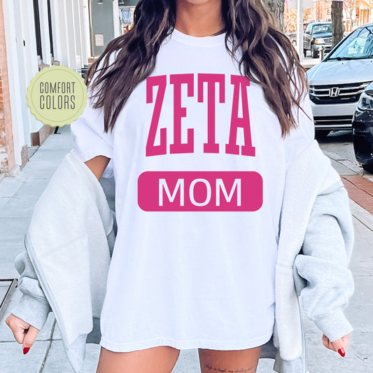 a woman wearing a white shirt that says zeta mom