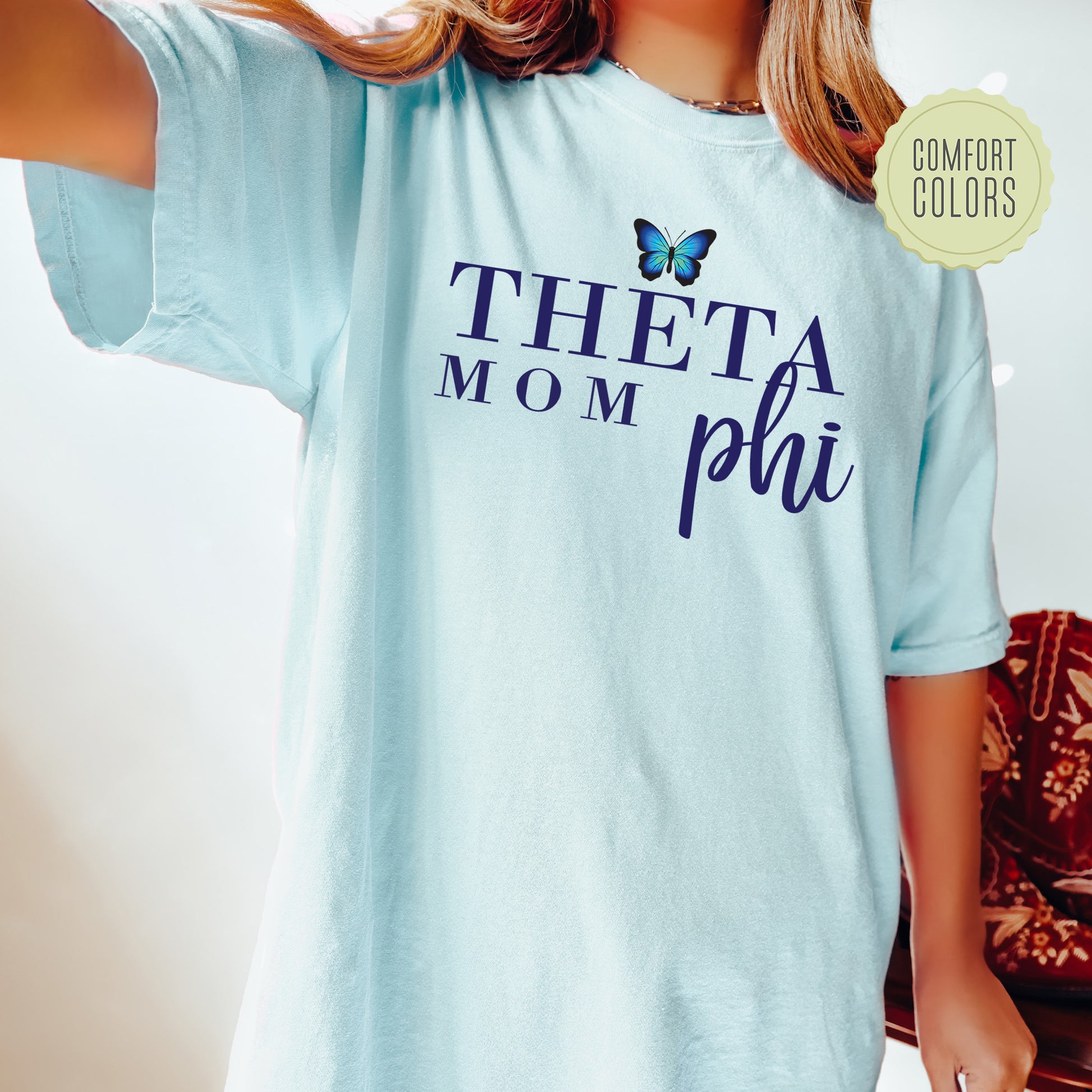 a woman wearing a blue shirt with a butterfly on it
