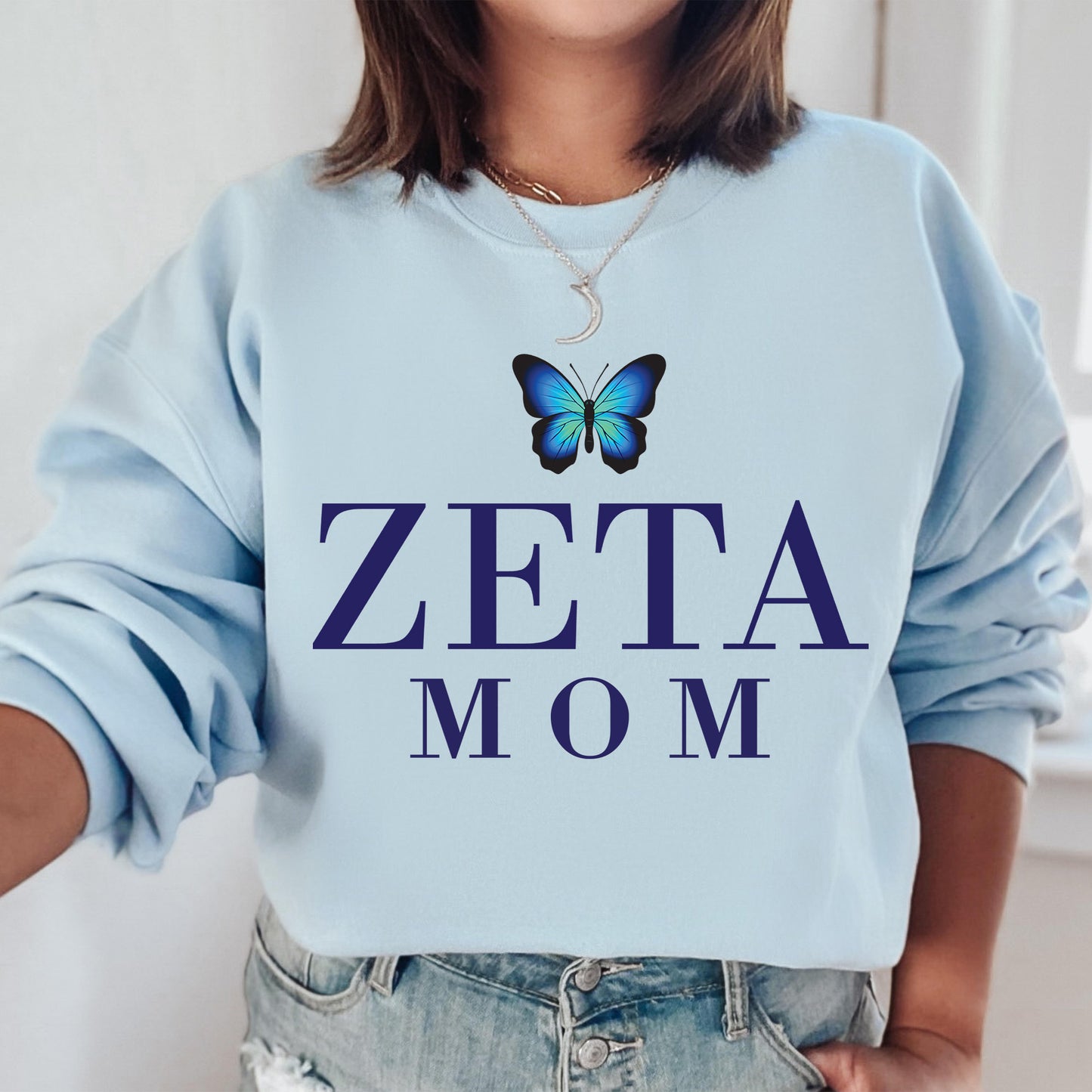 a woman wearing a blue sweatshirt with a butterfly on it