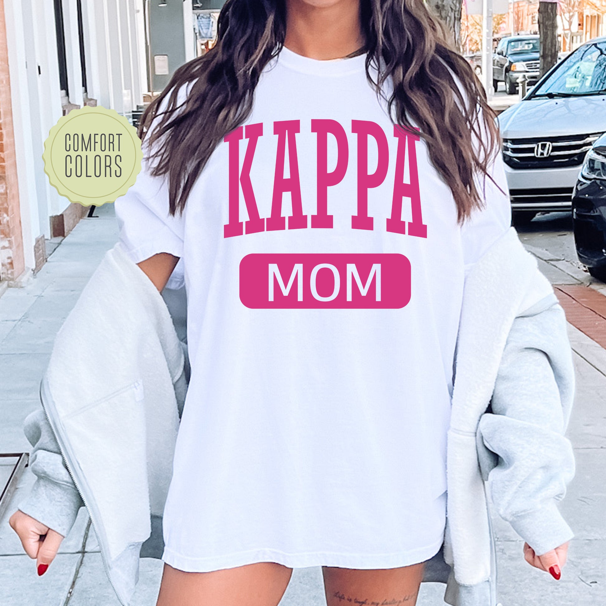 a woman wearing a white shirt that says kappa mom