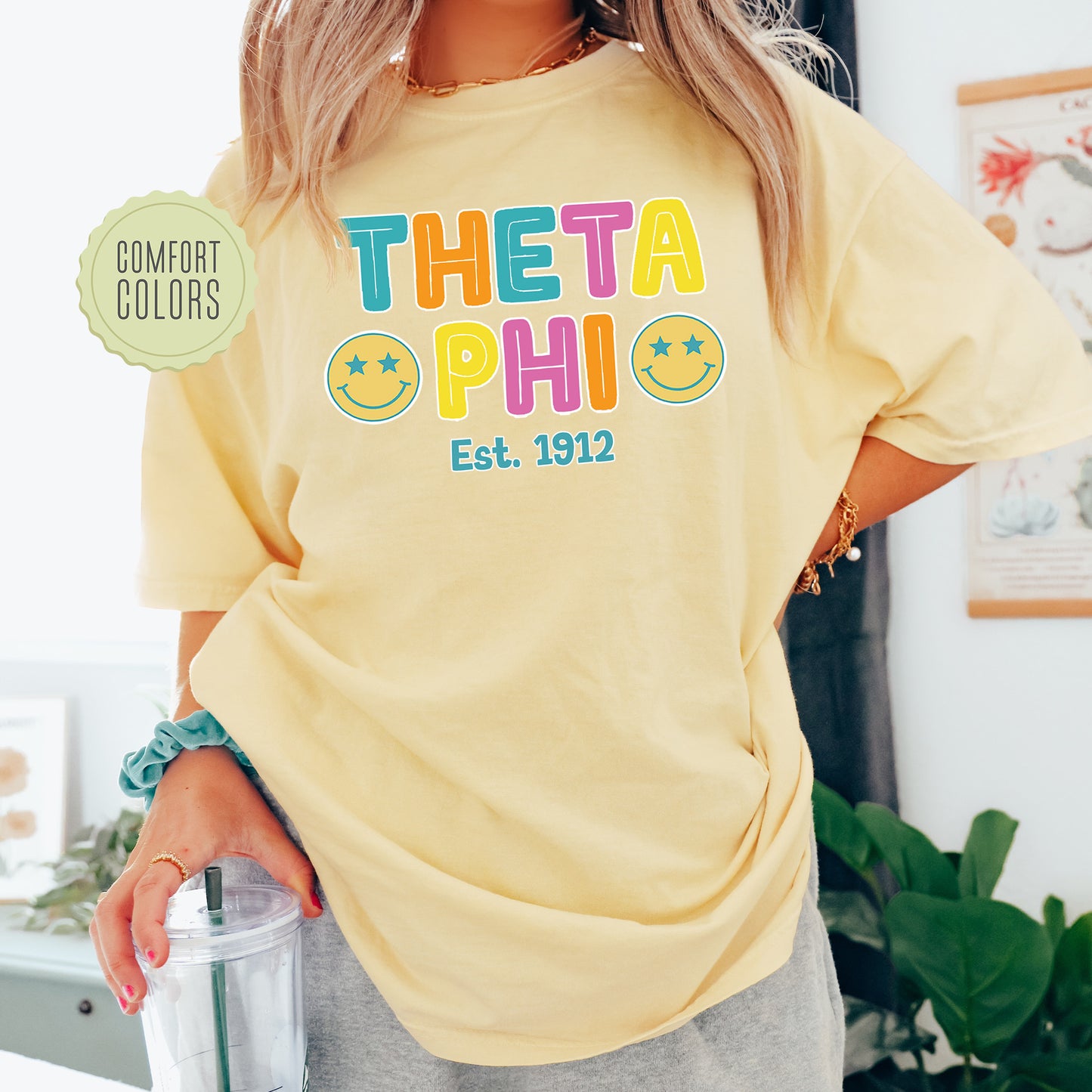 a woman wearing a yellow t - shirt with the words, thea phi est