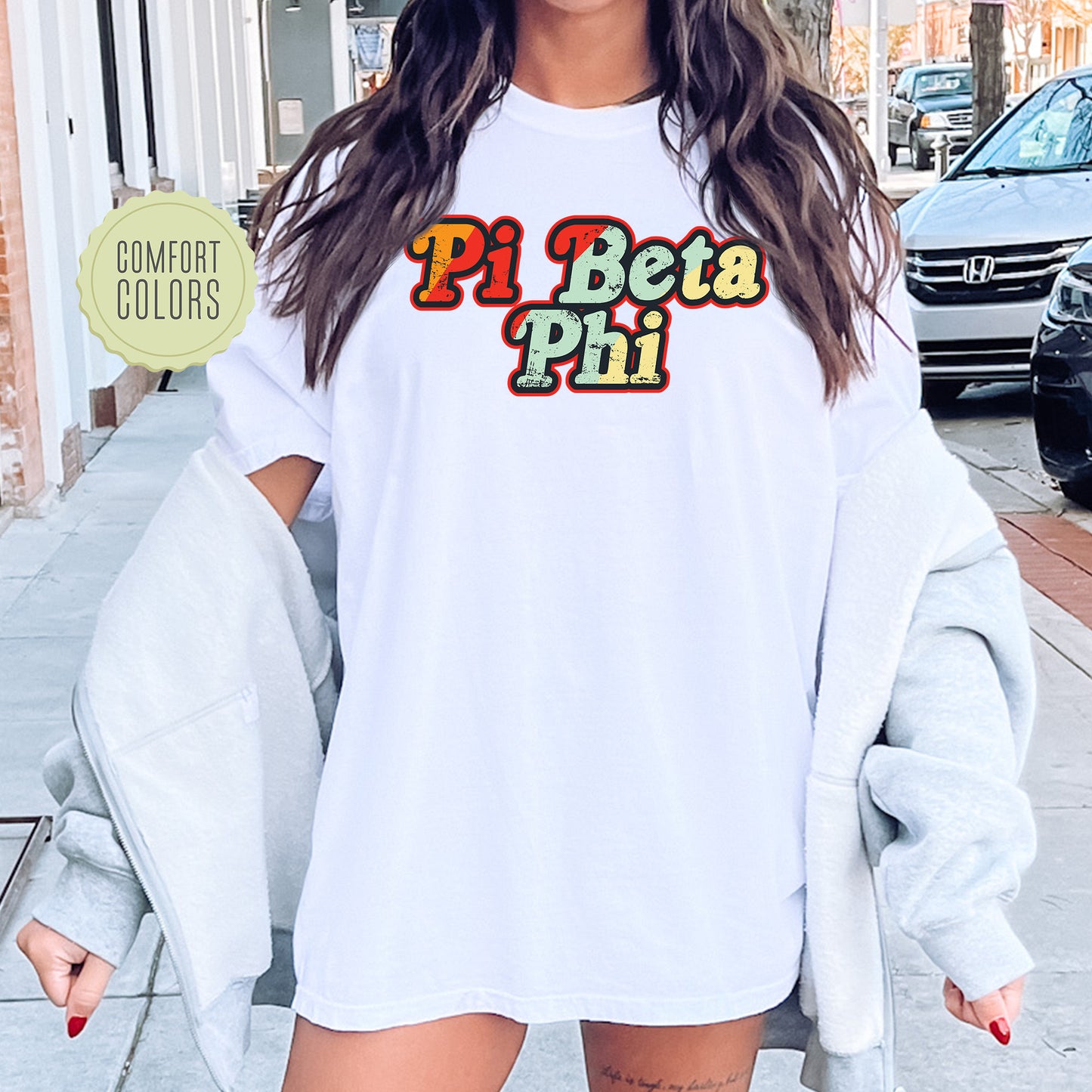 a woman wearing a white shirt with the word pi beta pi on it