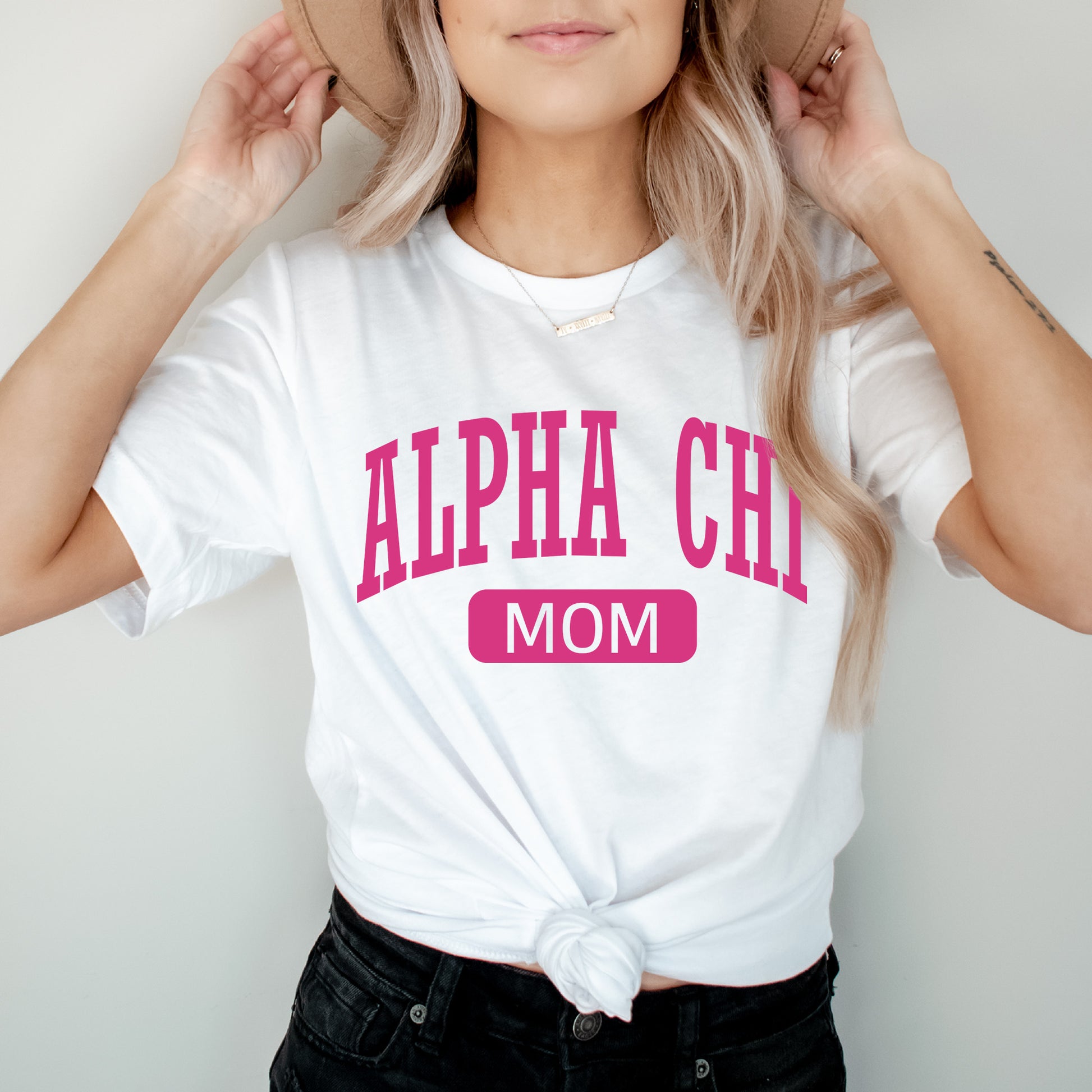 a woman wearing a white shirt with pink letters on it