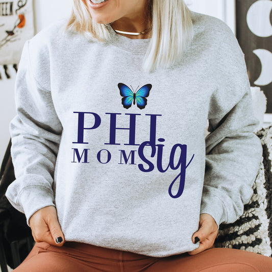 a woman sitting on a chair wearing a sweatshirt with a butterfly on it