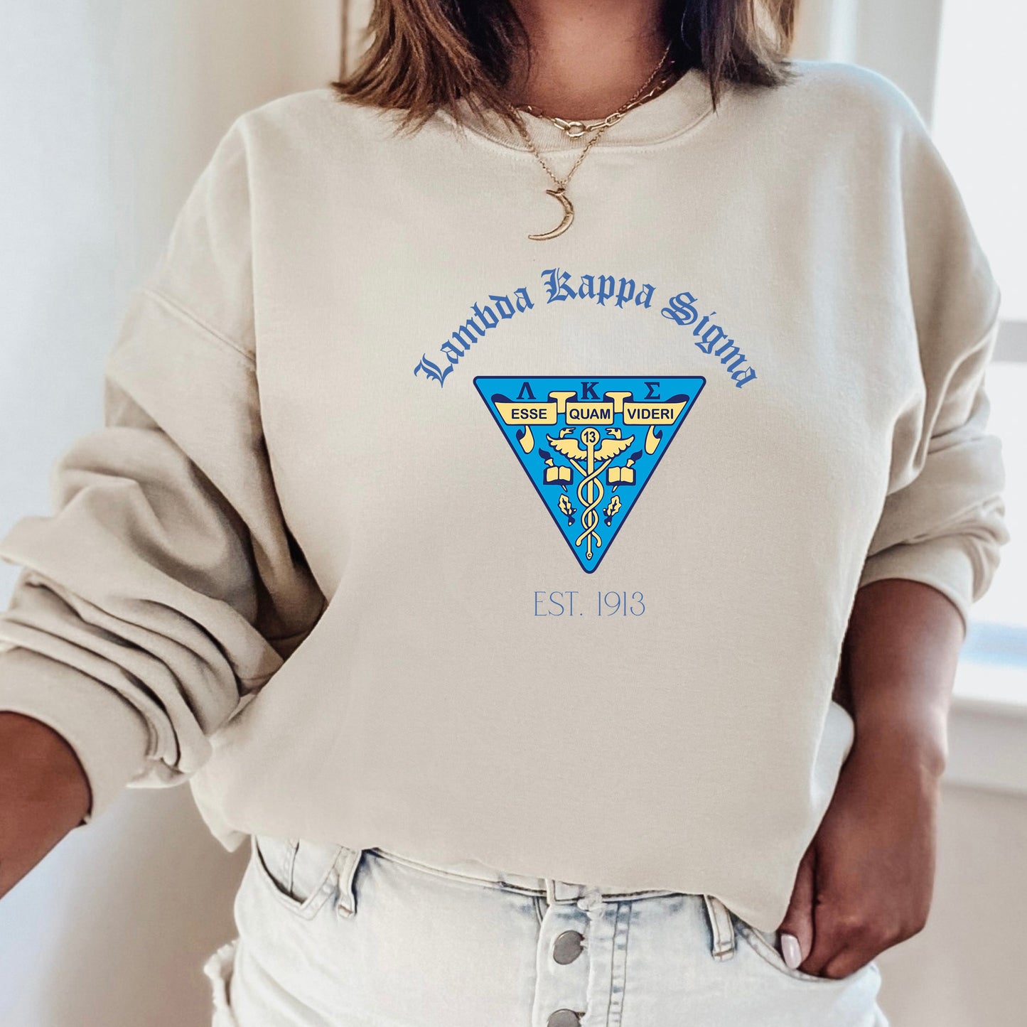 a woman wearing a white sweatshirt with a blue triangle on it