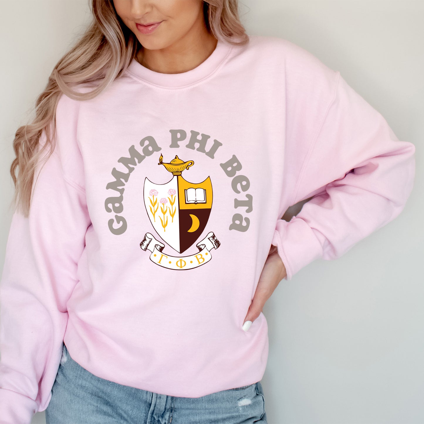 a woman wearing a pink sweatshirt and jeans