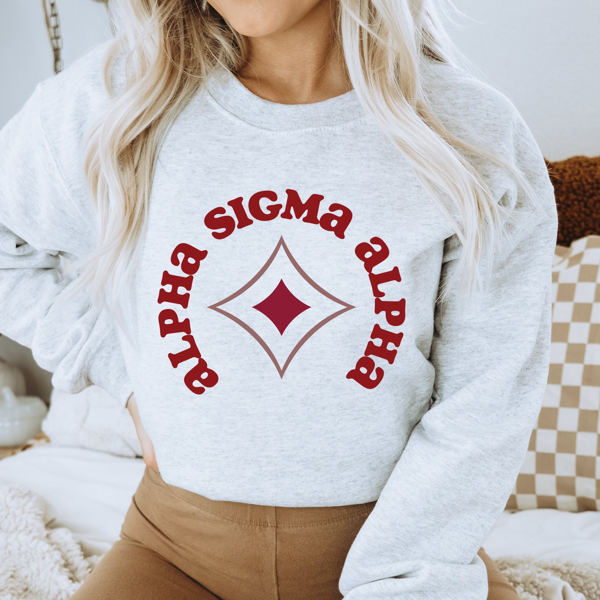 a woman wearing a white sweatshirt with a red logo