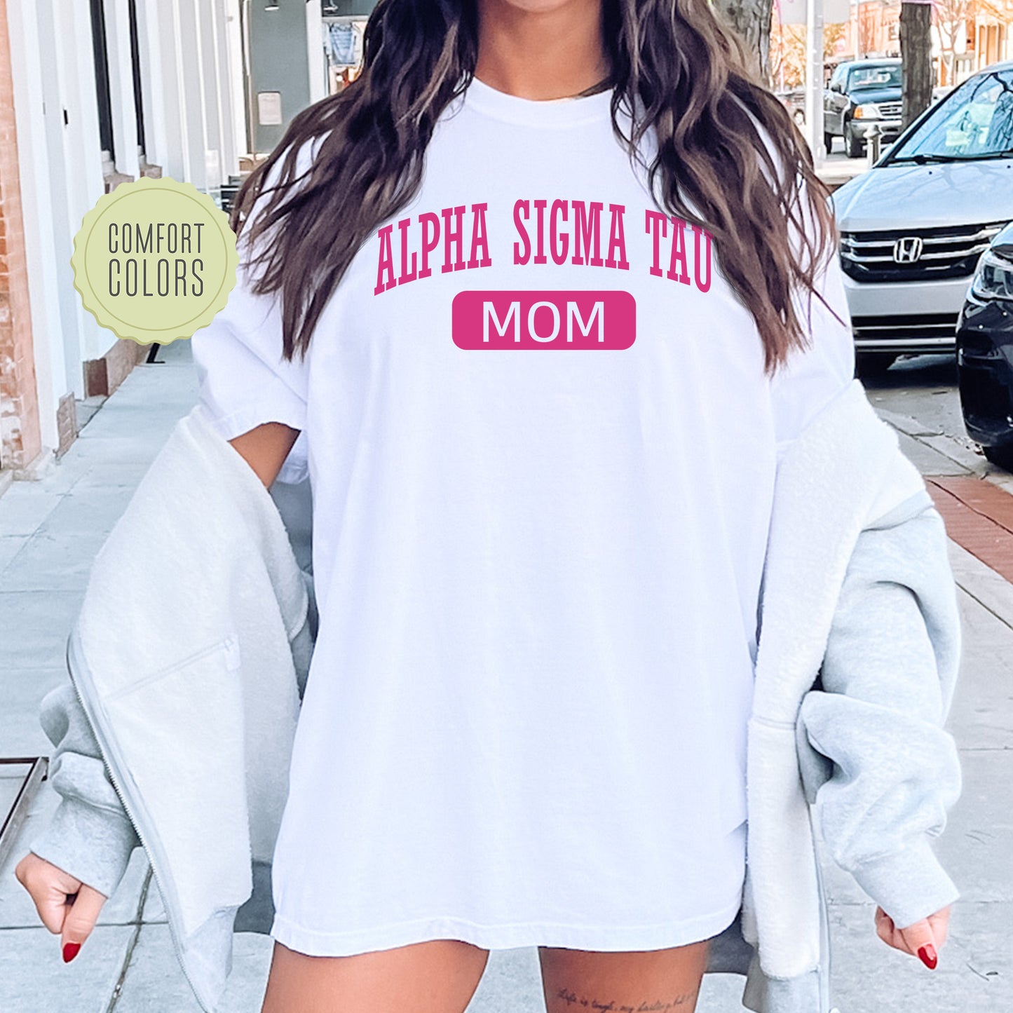 a woman wearing a white shirt with pink letters on it