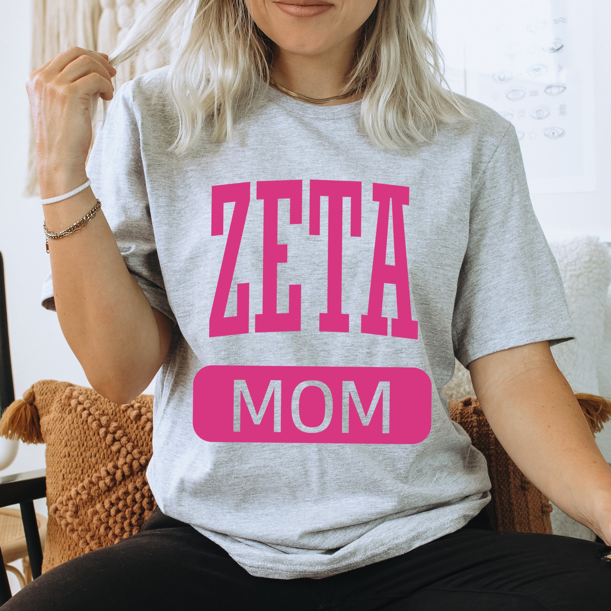 a woman sitting on a chair with a t - shirt that says zetta mom