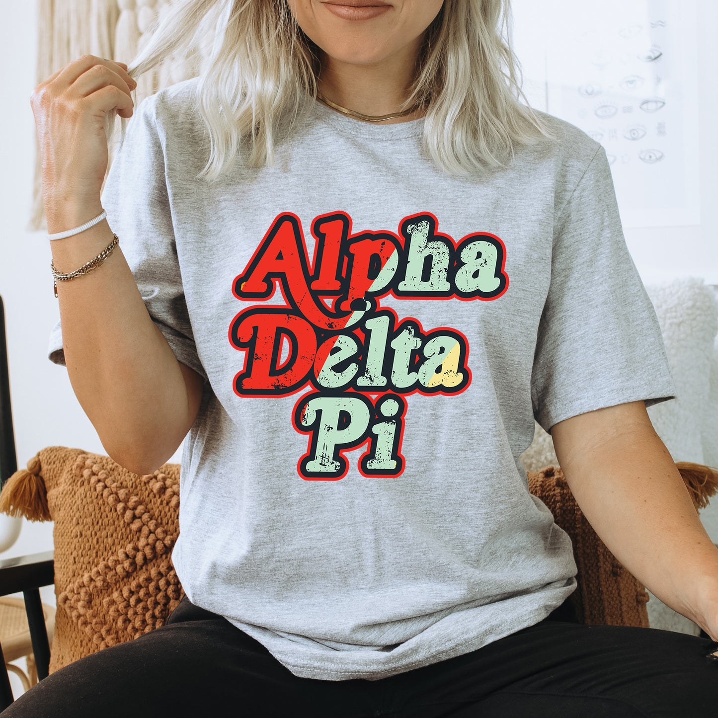a woman sitting on a chair wearing a shirt that says ahha delta pi