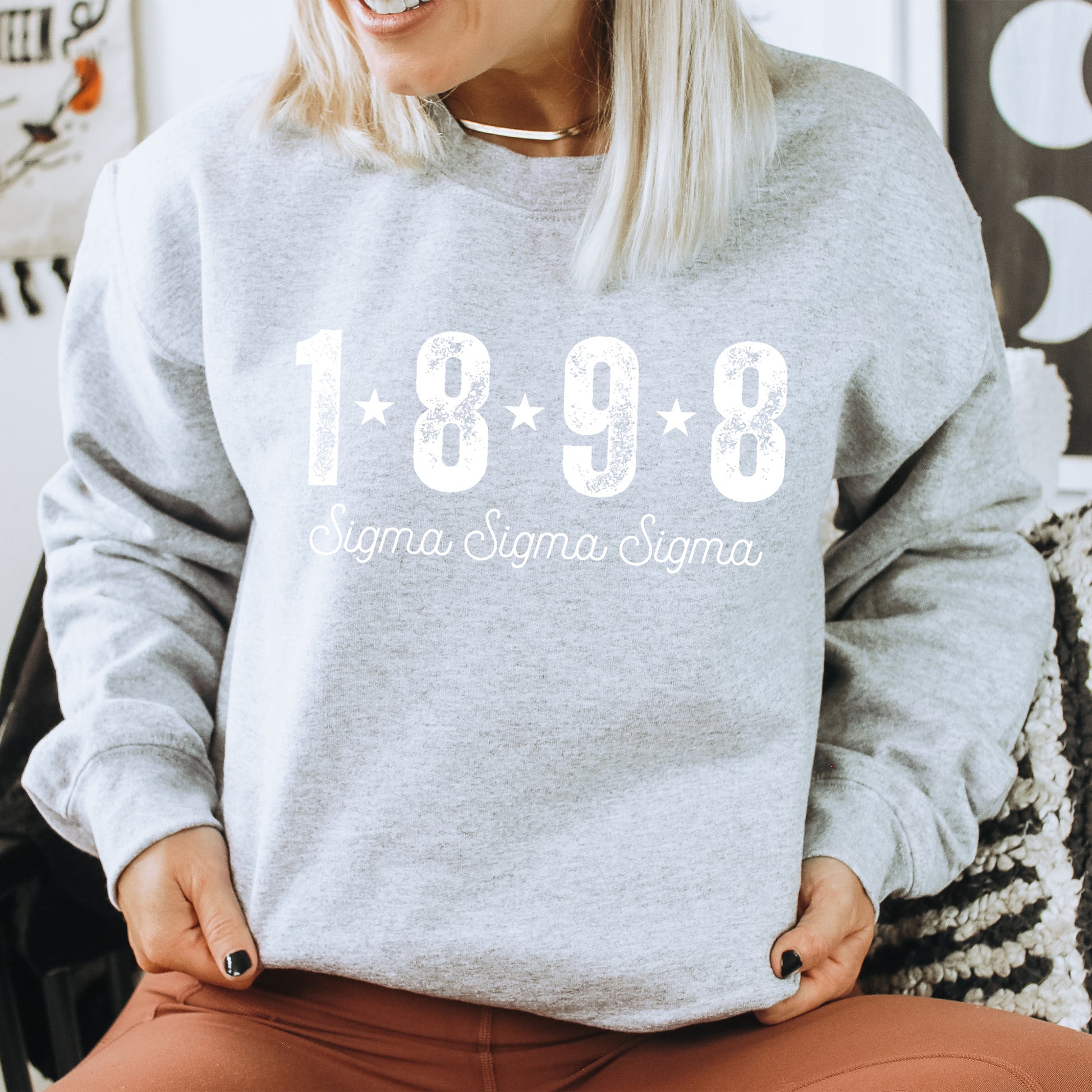 a woman sitting on a chair wearing a grey sweatshirt