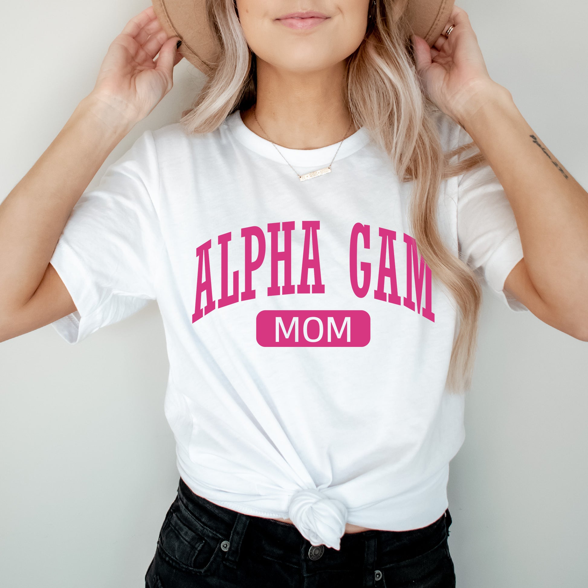 a woman wearing a white shirt with pink letters on it