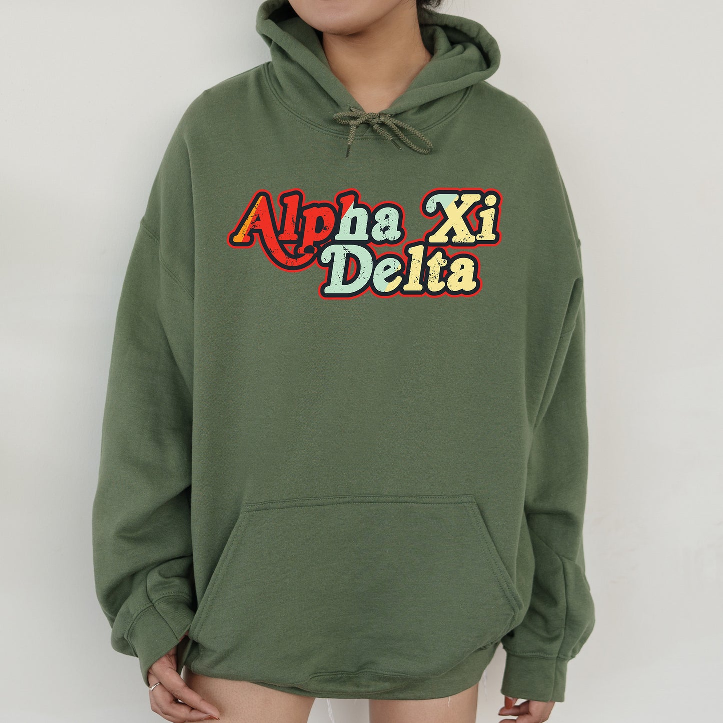 a woman wearing a green hoodie with the words aloha xi delta on