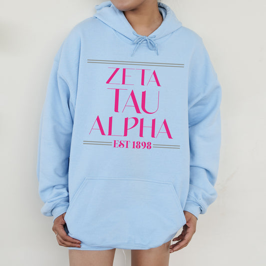 a person wearing a blue hoodie with pink letters on it