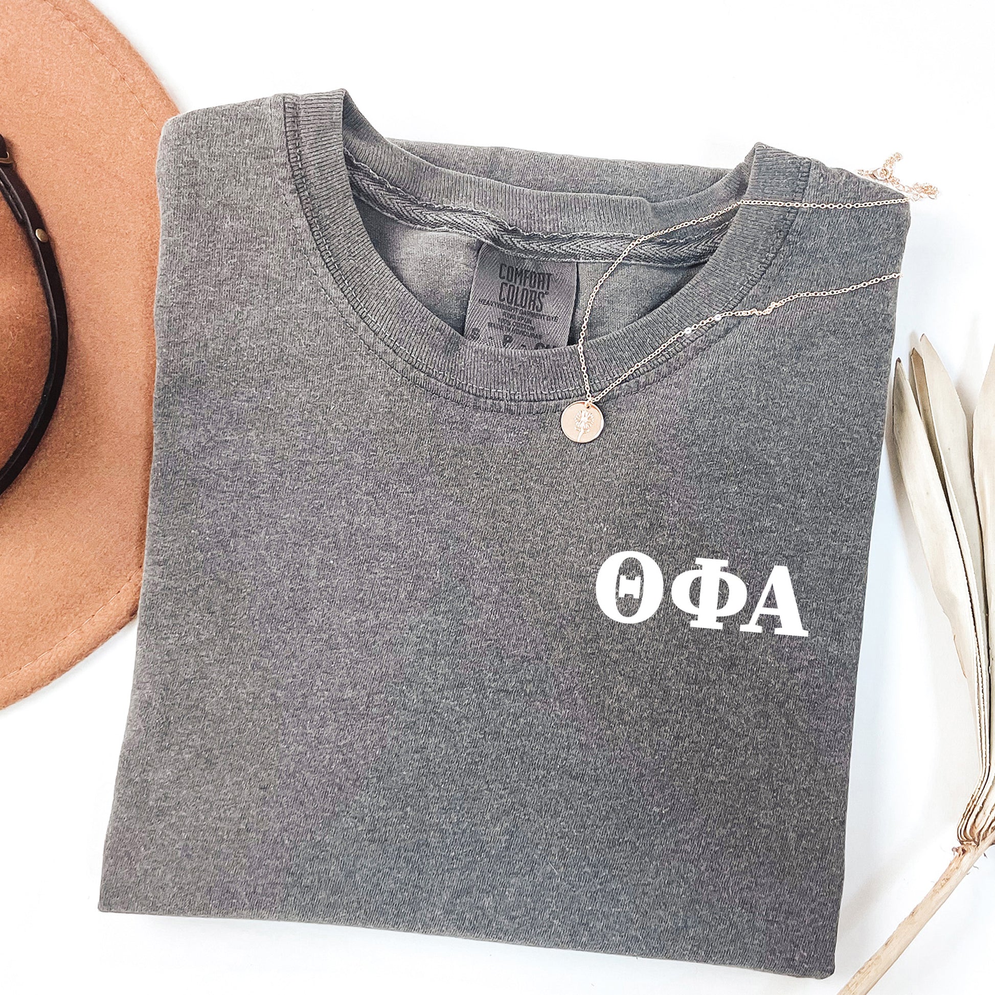 a hat, sunglasses, and t - shirt on a white surface