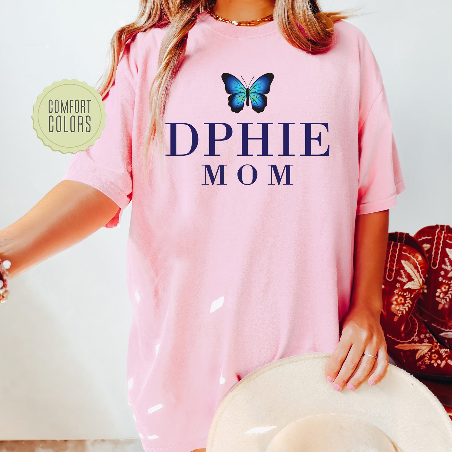 a woman wearing a pink shirt with a butterfly on it
