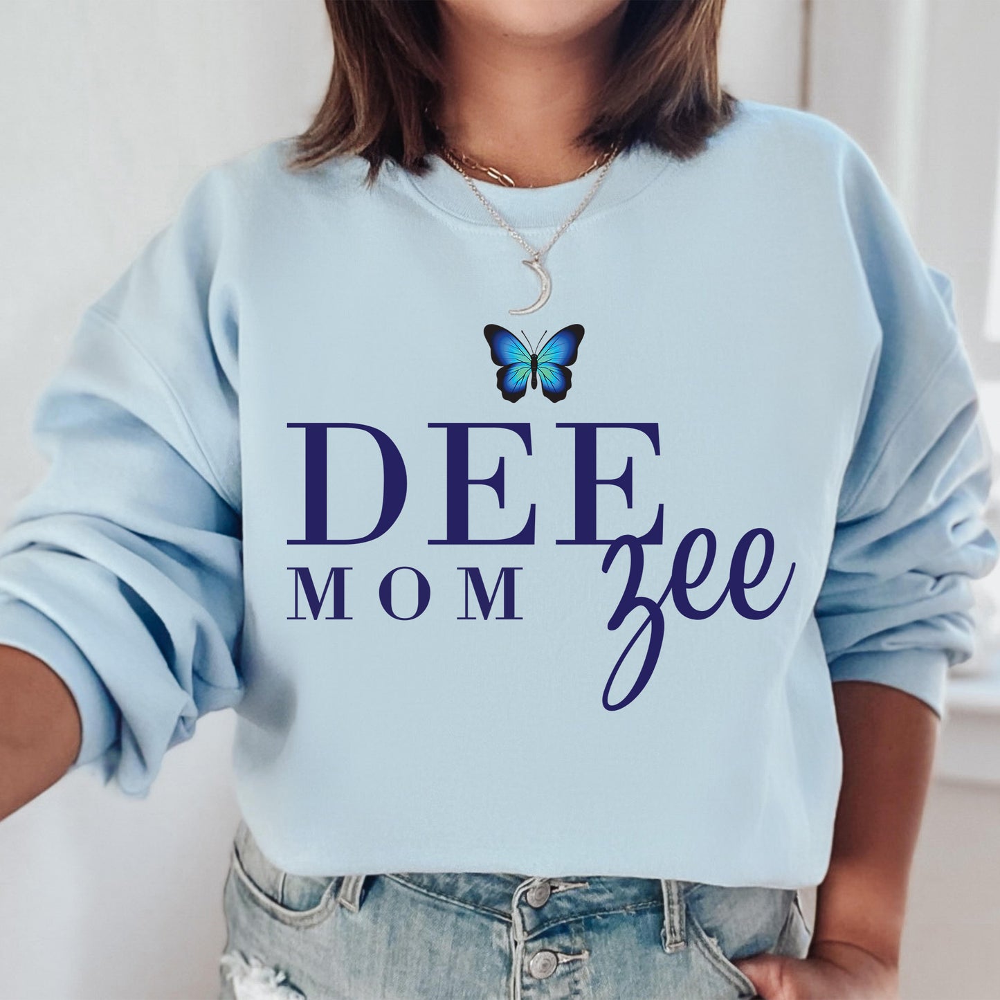 a woman wearing a blue sweatshirt with a butterfly on it