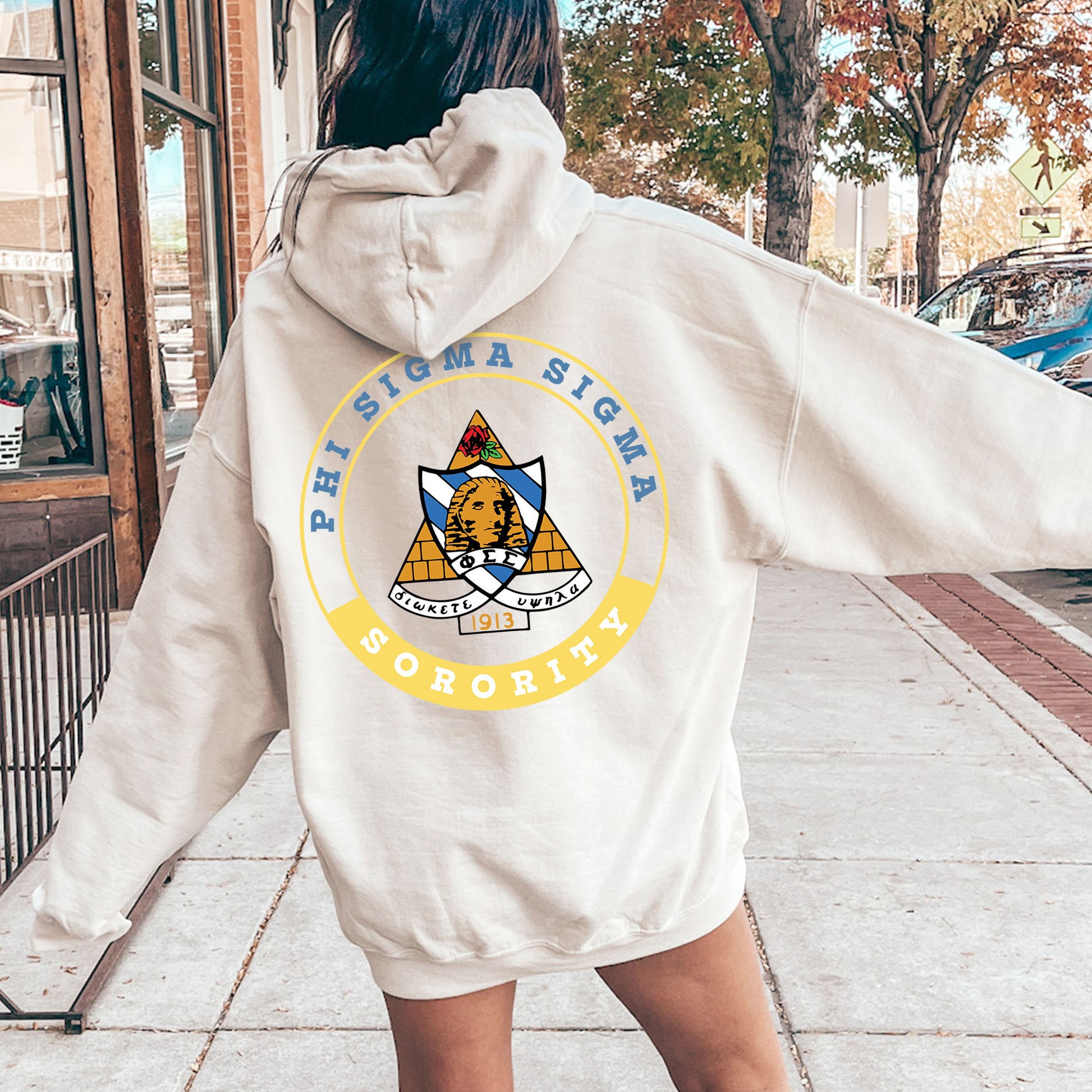 a woman in a white hoodie is walking down the street