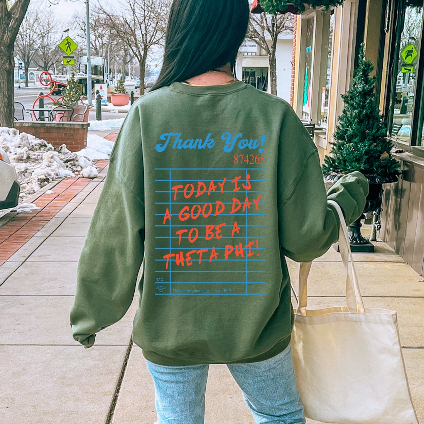 a woman walking down a sidewalk carrying a bag