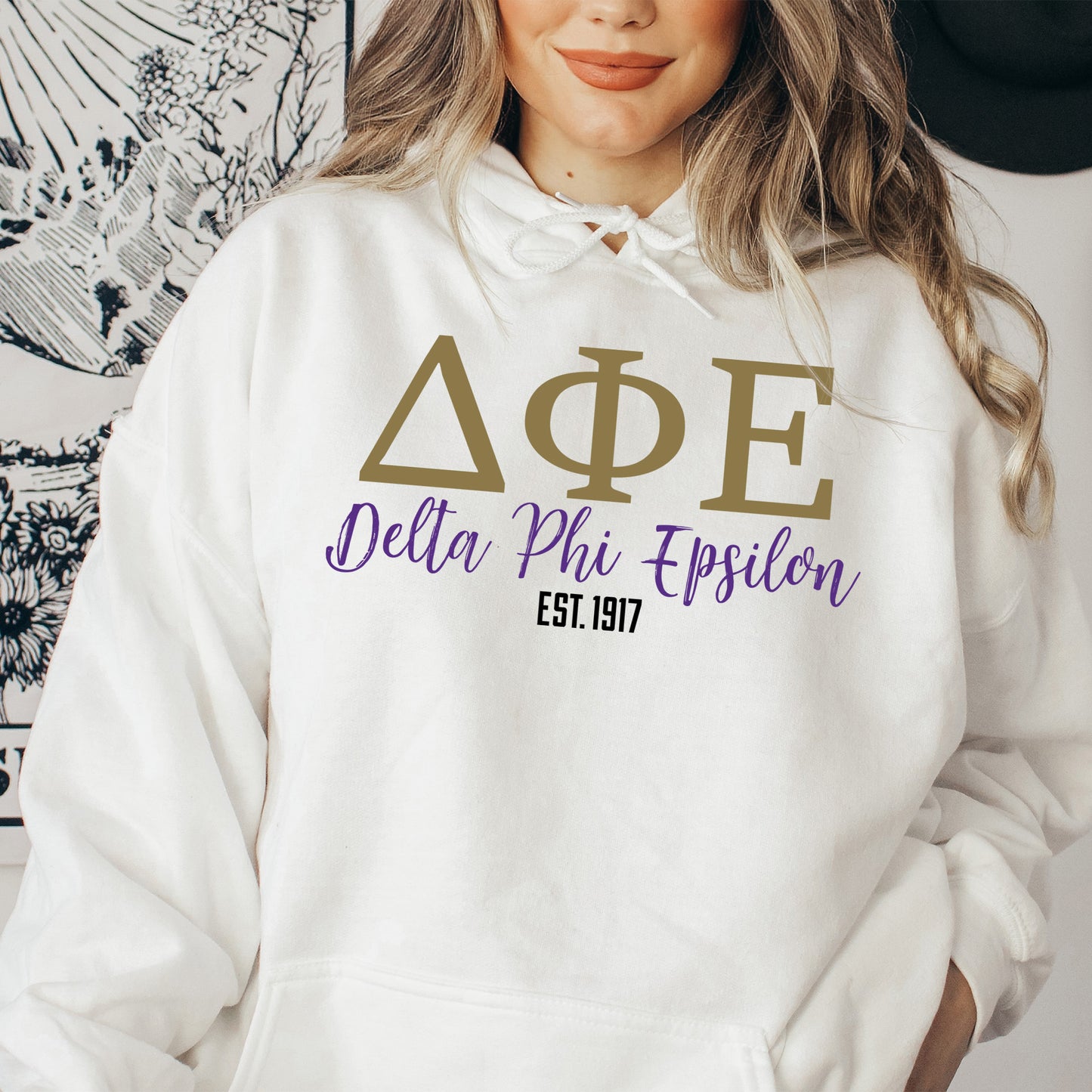 a woman wearing a white hoodie that says delta phi epiloon
