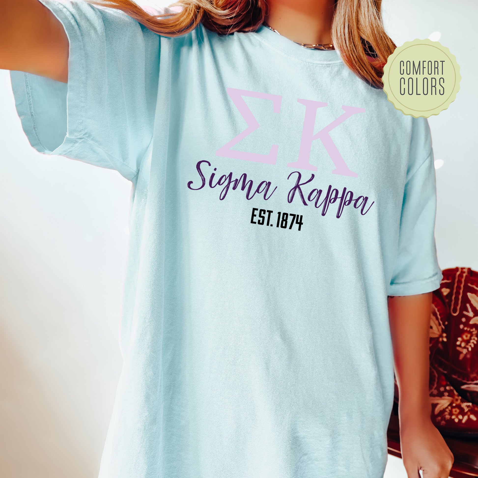 a woman wearing a blue tshirt with pink letters on it