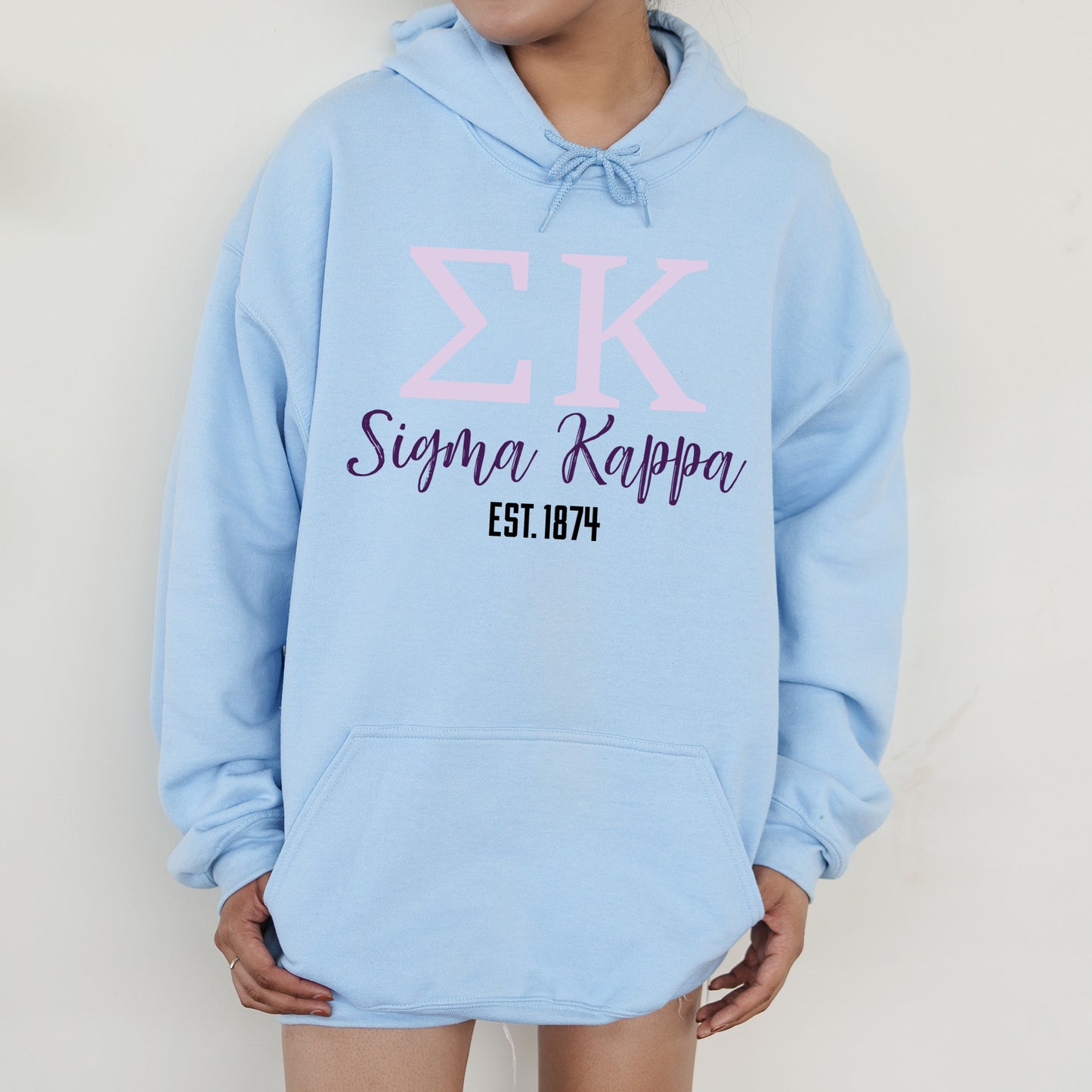 a person wearing a blue hoodie with a pink zk on it