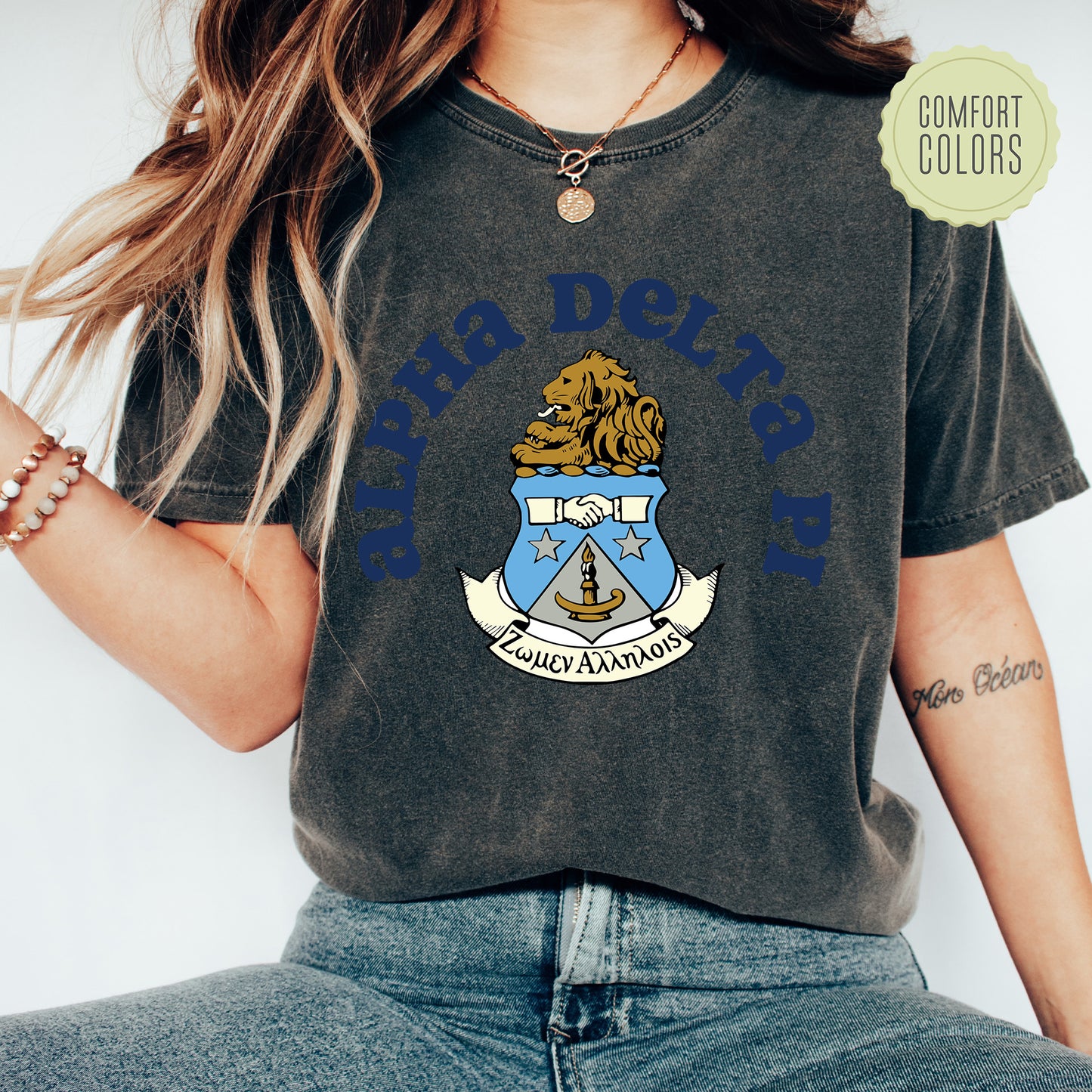 a woman wearing a t - shirt with a coat of arms on it