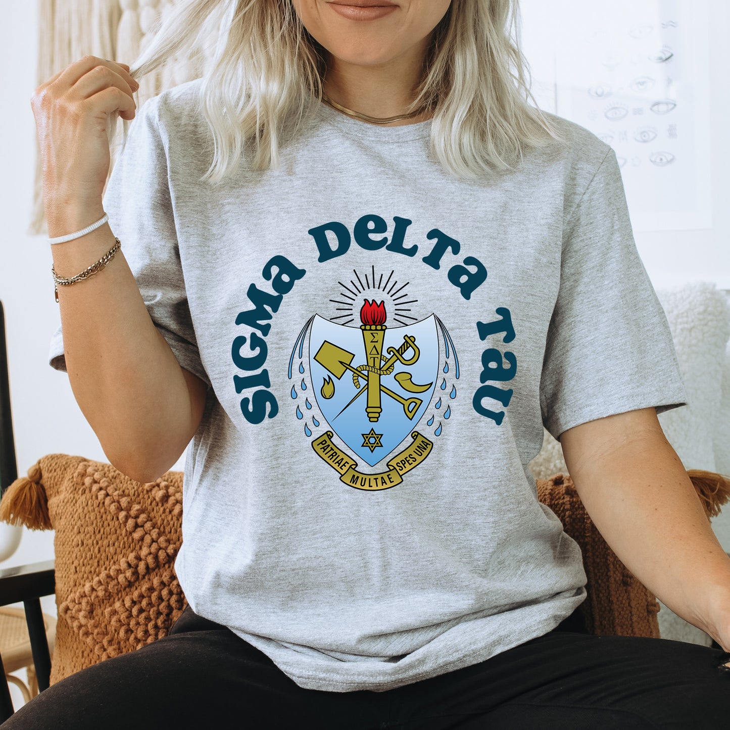 a woman sitting on a chair wearing a t - shirt with a coat of arms