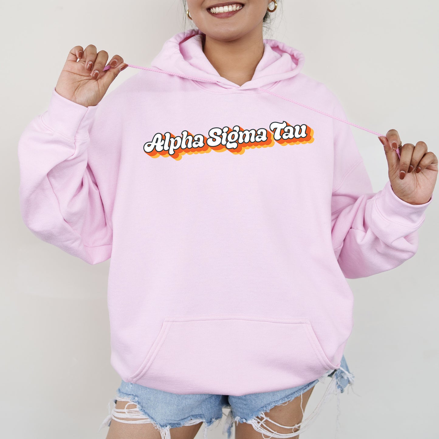 a woman wearing a pink hoodie with the words aphia sigina tau on