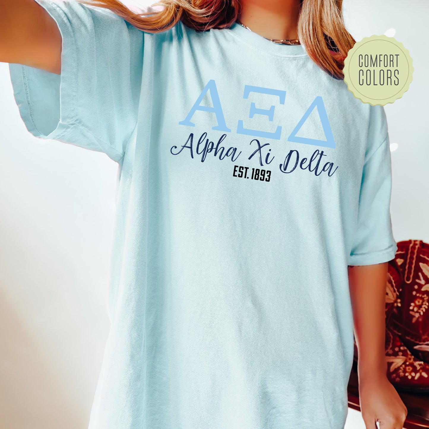 a woman wearing a light blue shirt with a delta shirt on it