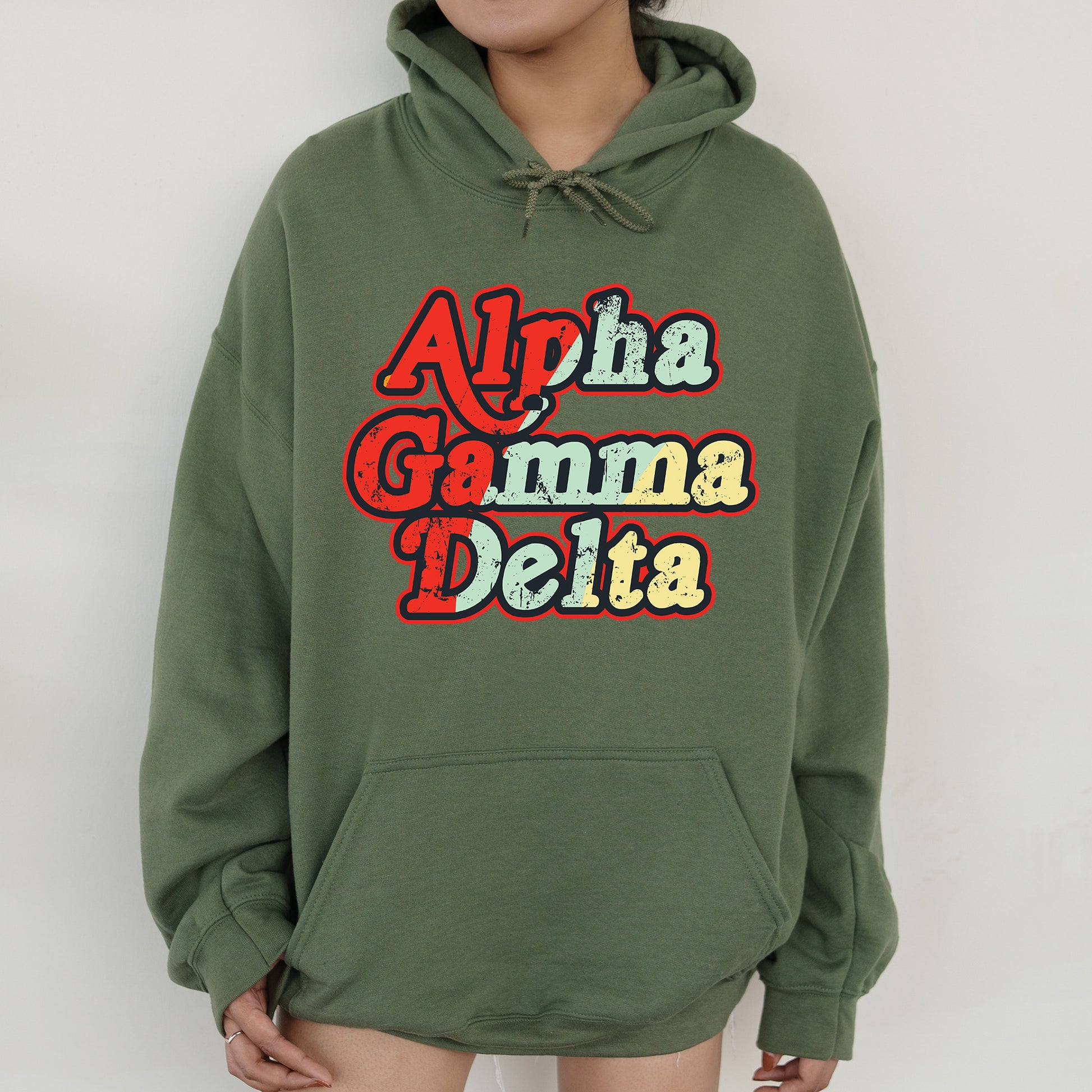 a woman wearing a green hoodie with the words aloha gamma delta