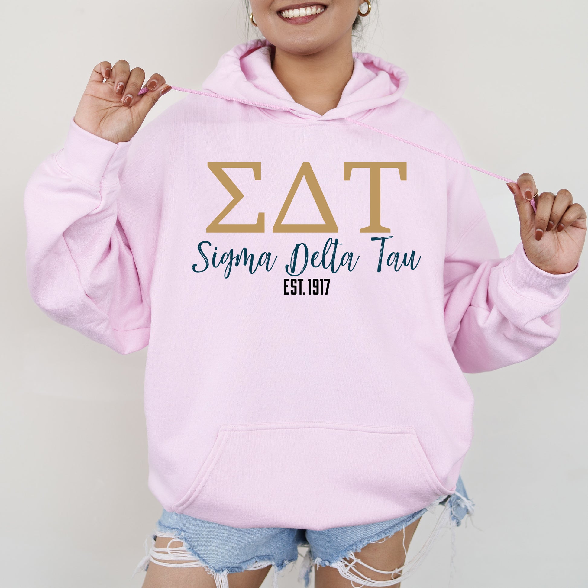 a woman wearing a pink hoodie with the word zat on it