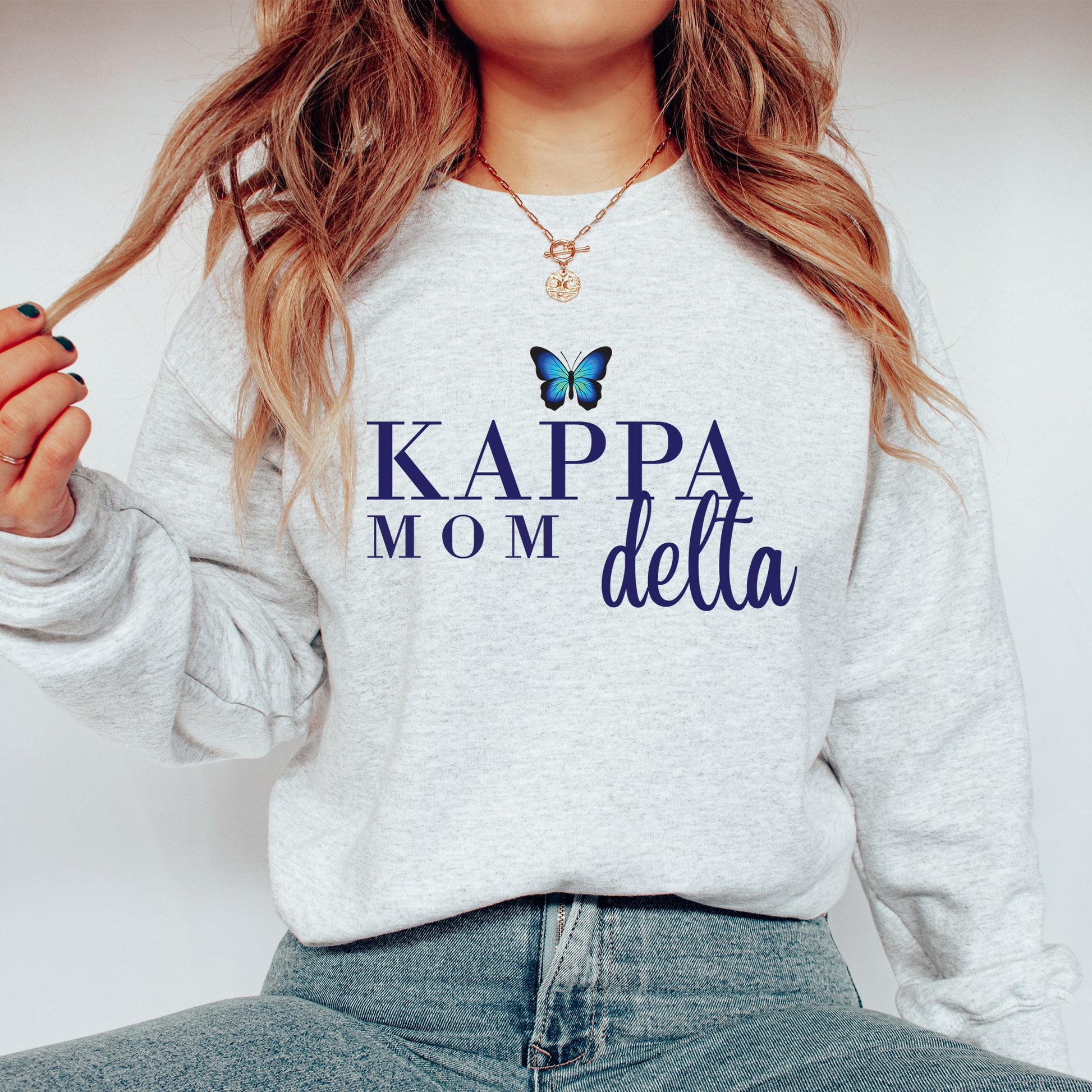 a woman wearing a sweatshirt that says kapp mom delta