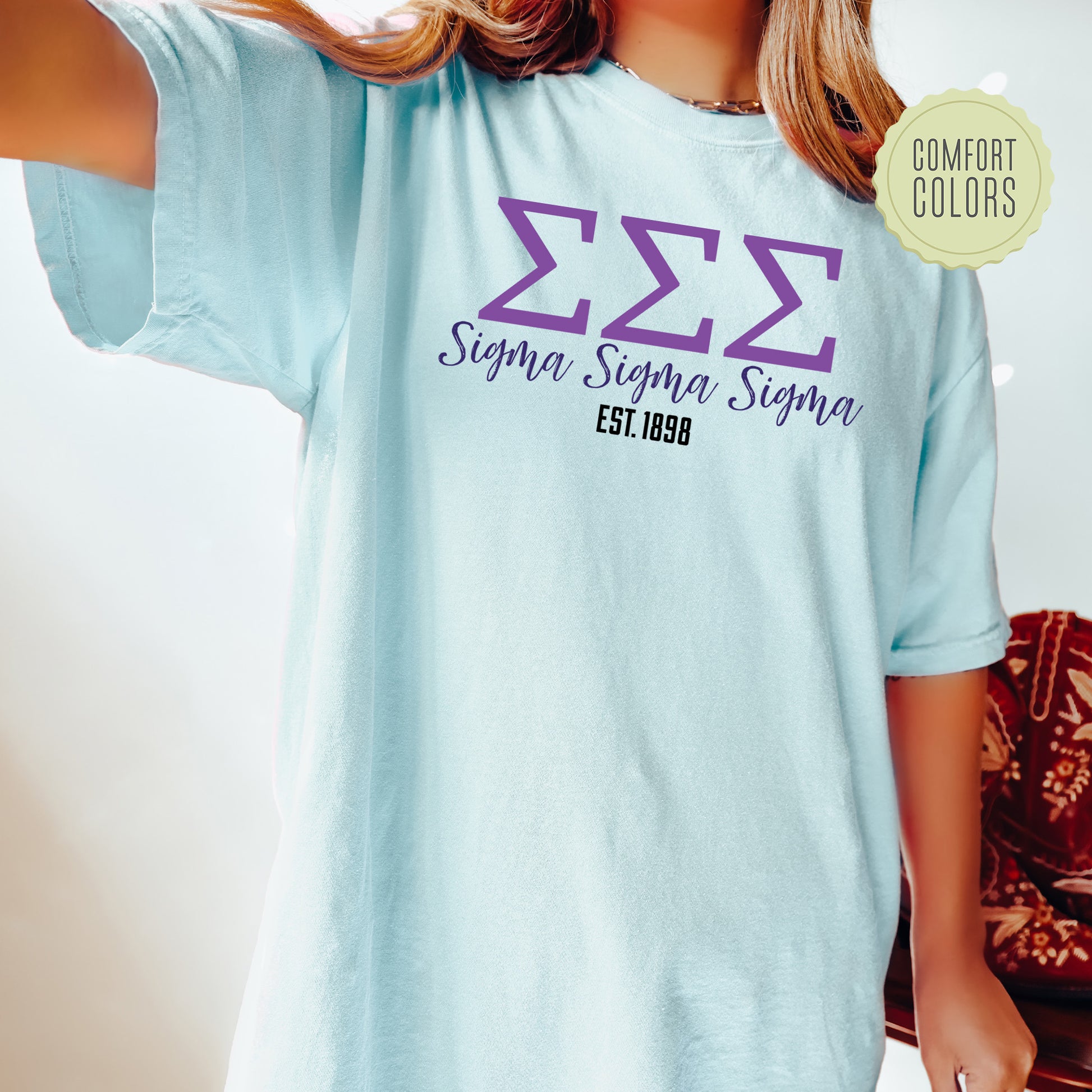a woman wearing a blue tshirt with purple letters on it