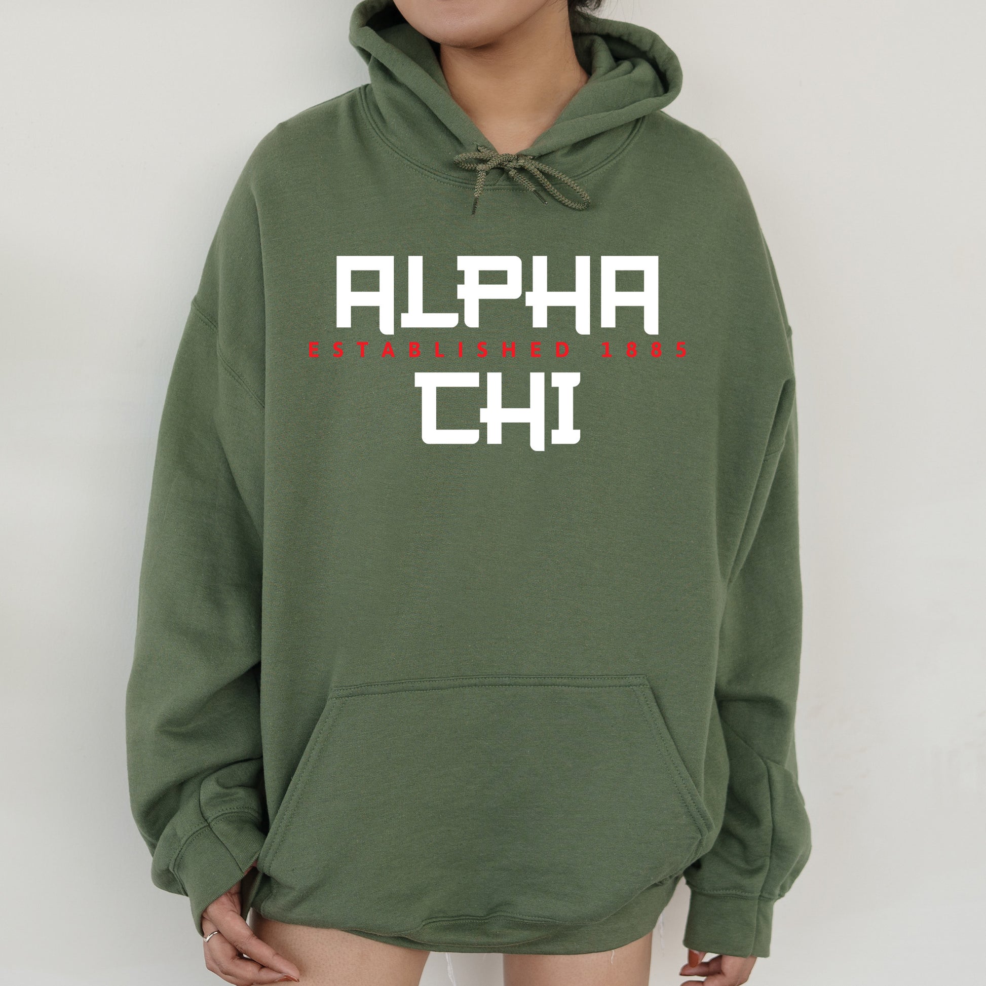 a person wearing a green hoodie with the words alph chi on it