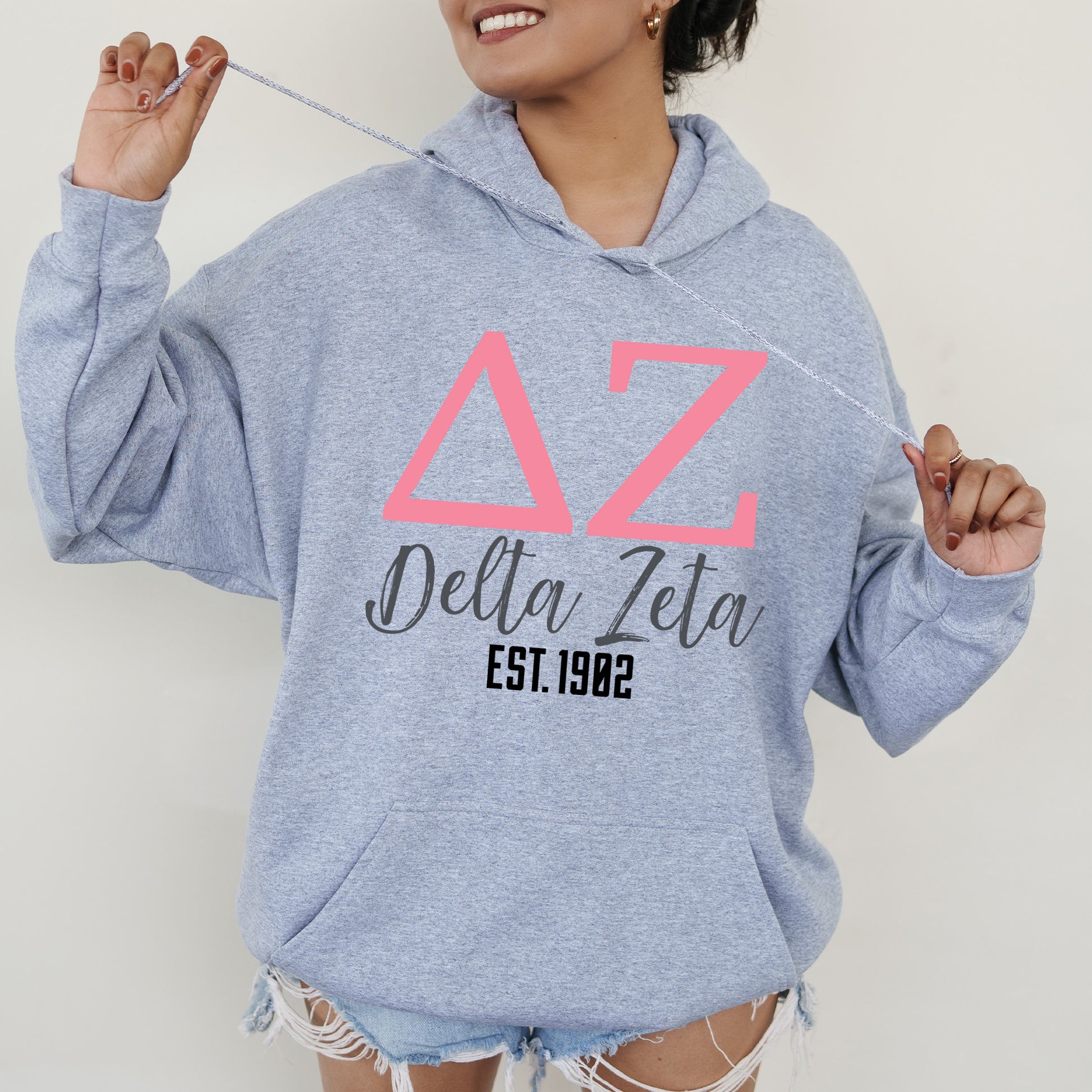 a woman in a blue hoodie is holding a string