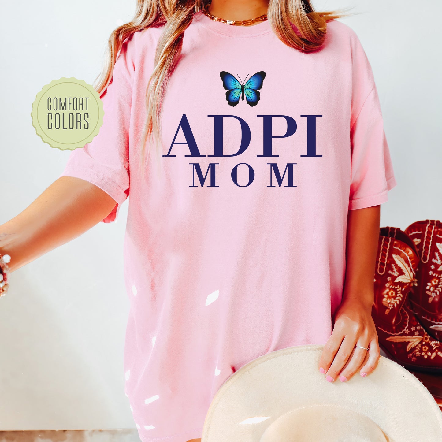 a woman wearing a pink shirt with a butterfly on it