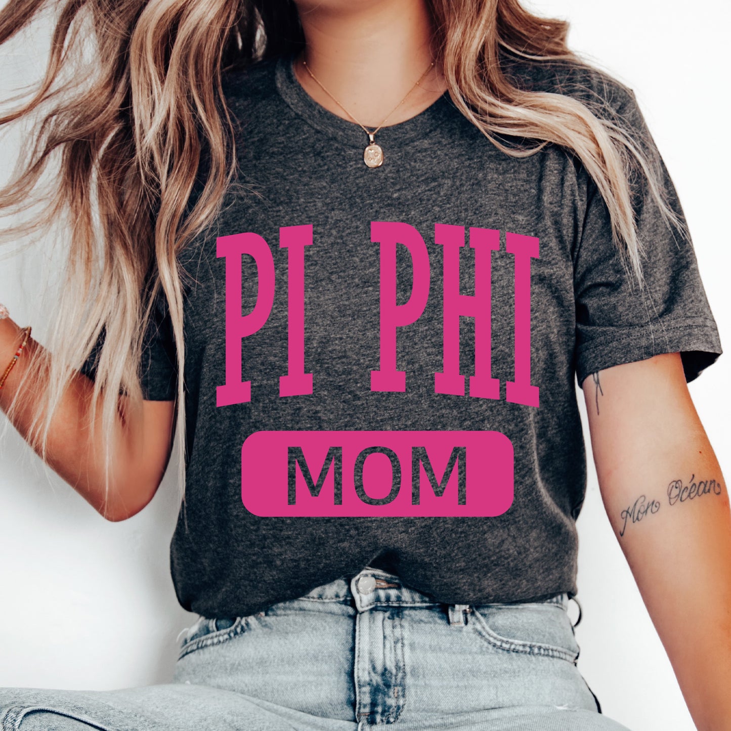 a woman wearing a pi phi mom shirt