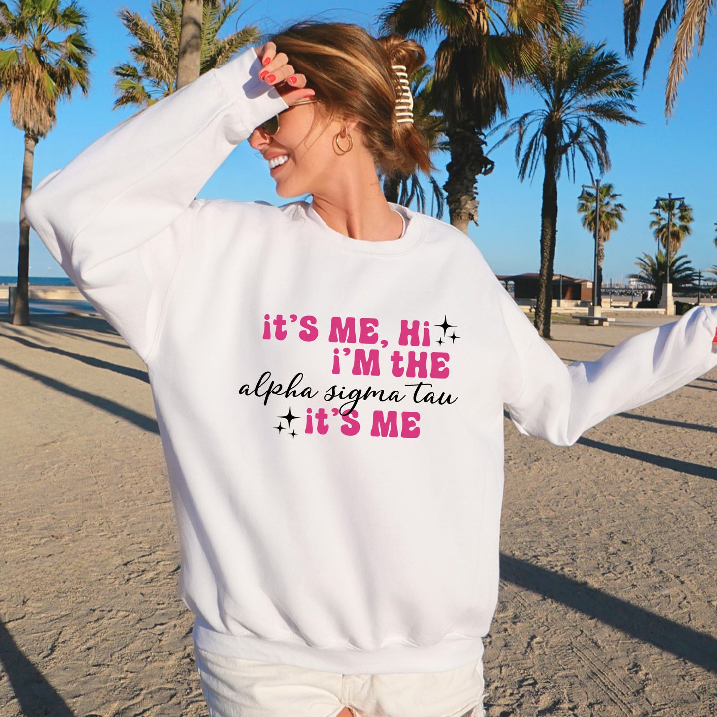 a woman standing on a beach wearing a sweatshirt that says it's me,