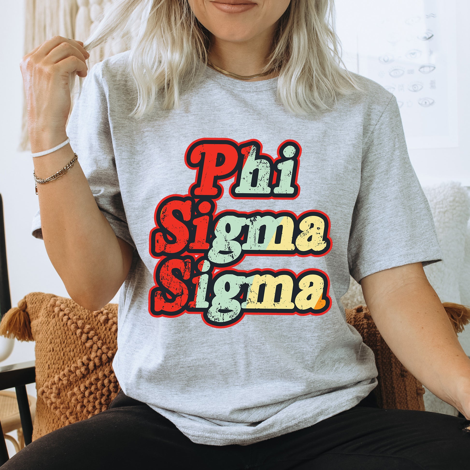 a woman sitting on a chair wearing a phi sigma shirt