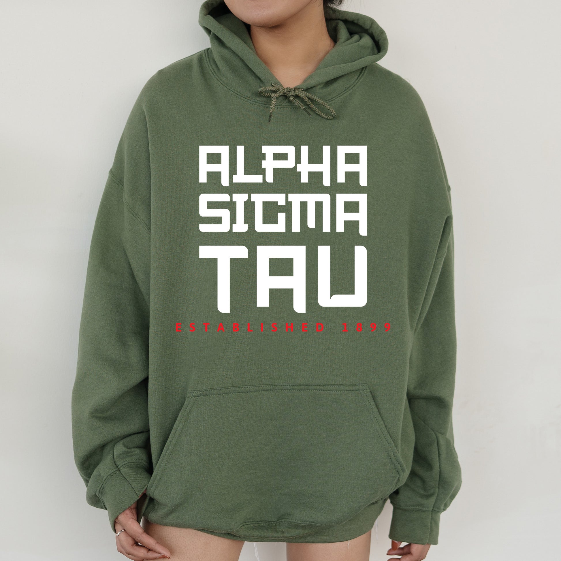 a person wearing a green hoodie with the words alpha sigma