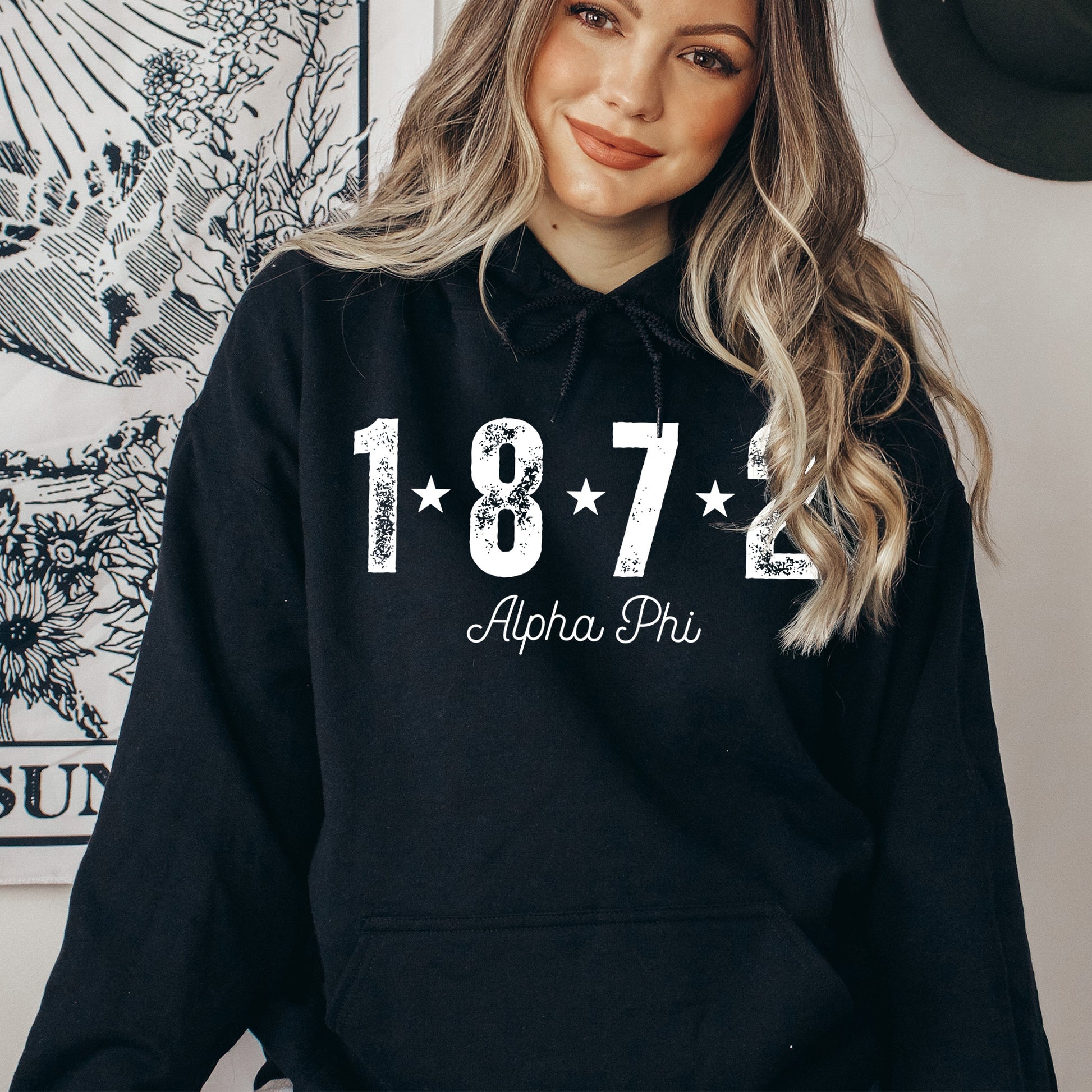 a woman wearing a black hoodie with white lettering