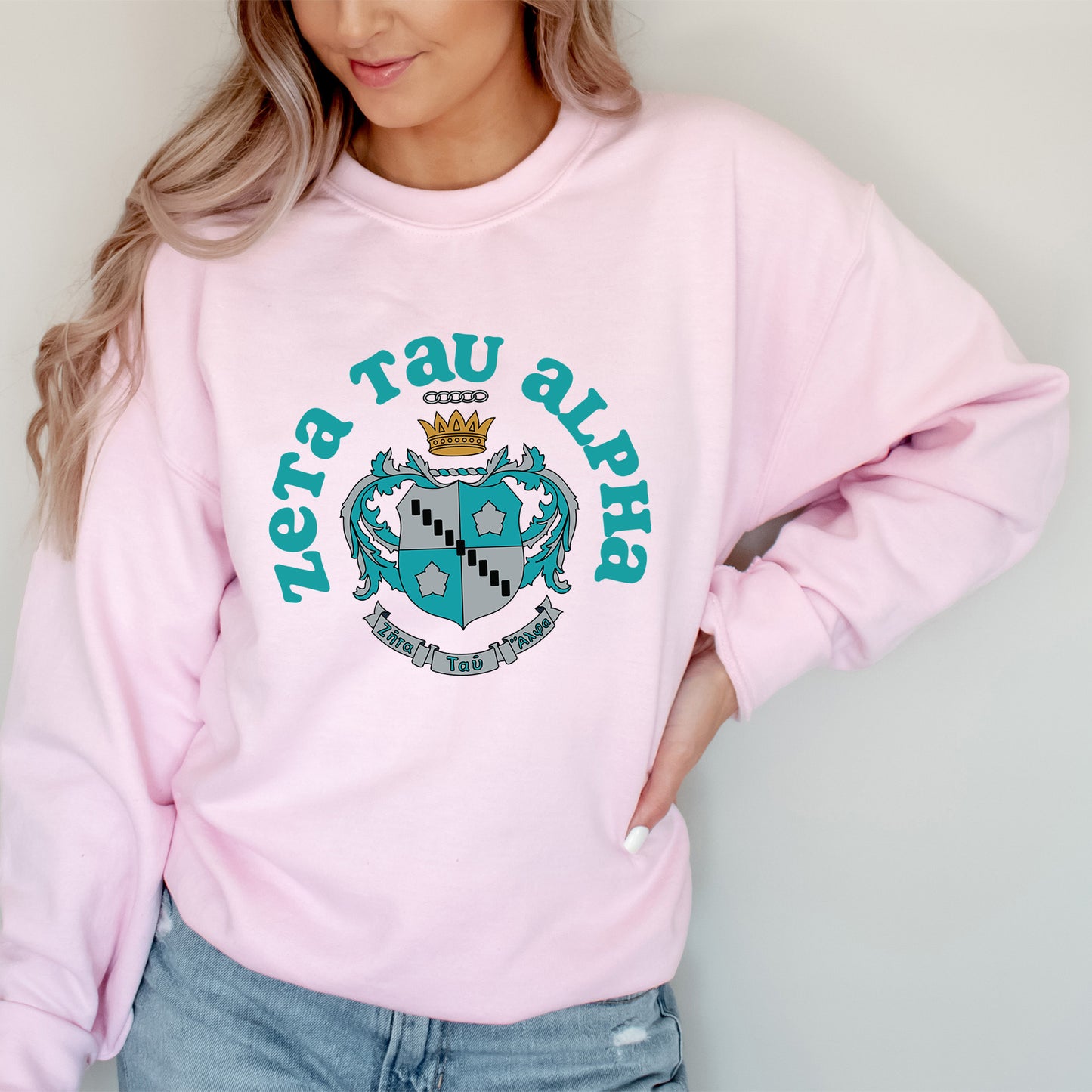 a woman wearing a pink sweater with a crown on it
