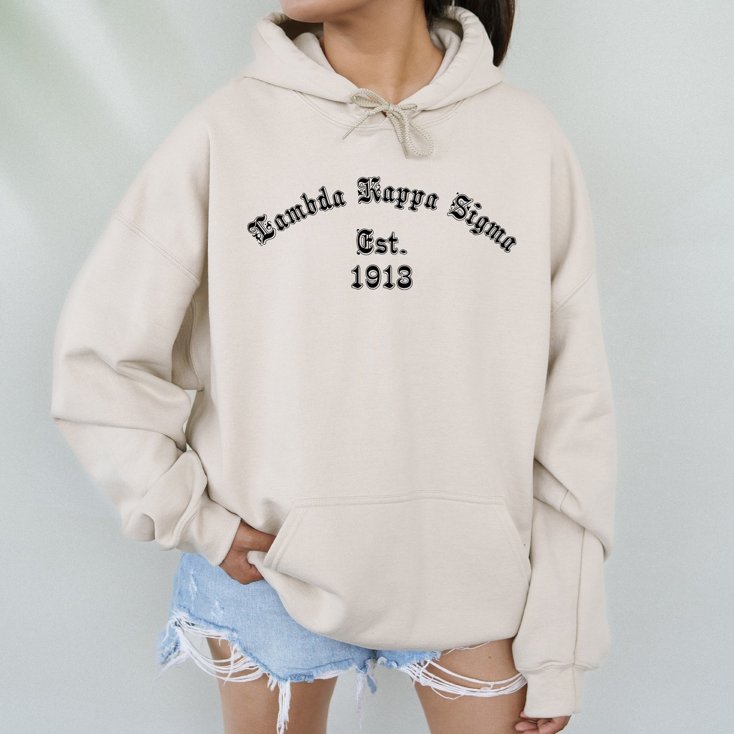 a woman wearing a white hoodie with the words behind her