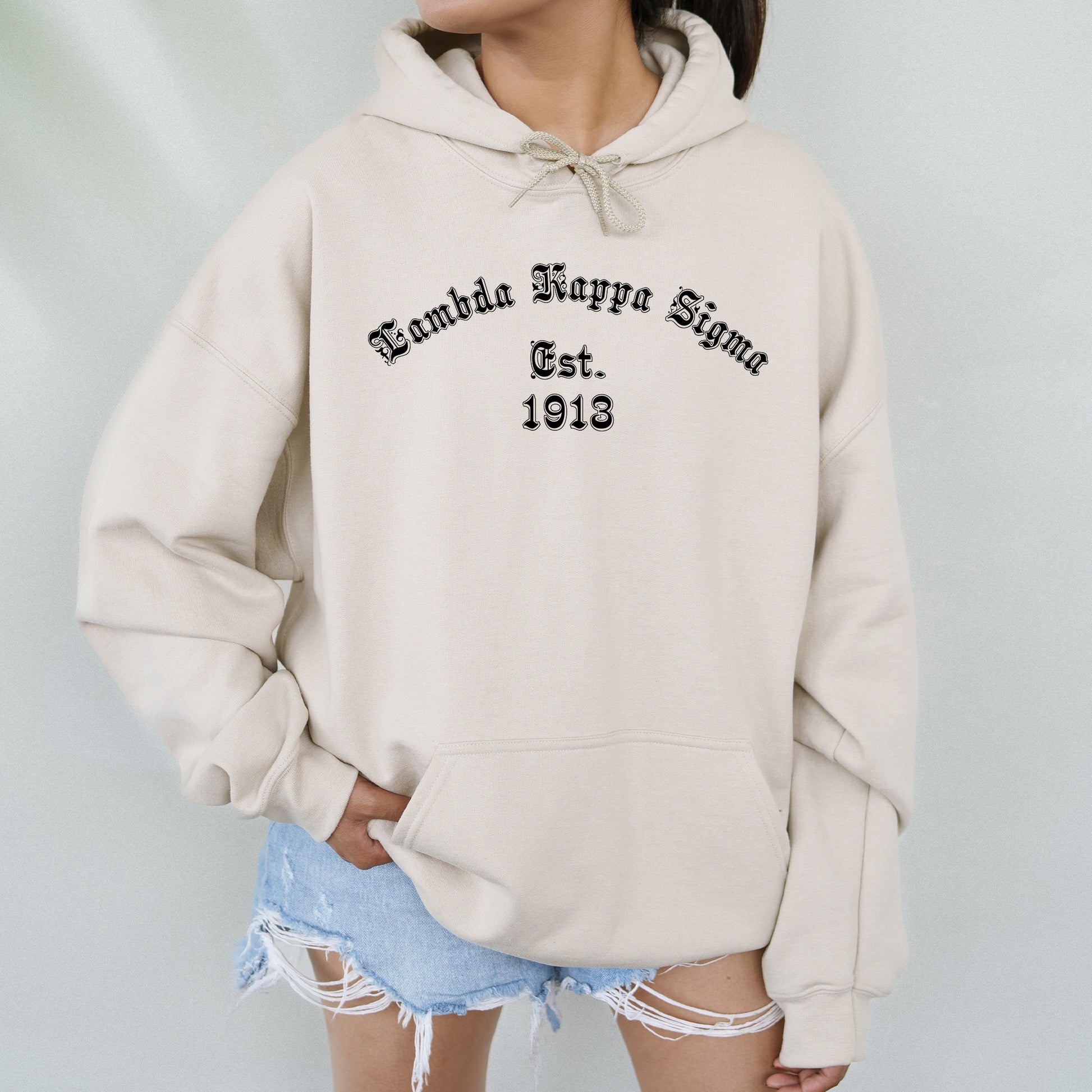 a woman wearing a white hoodie with the words behind her