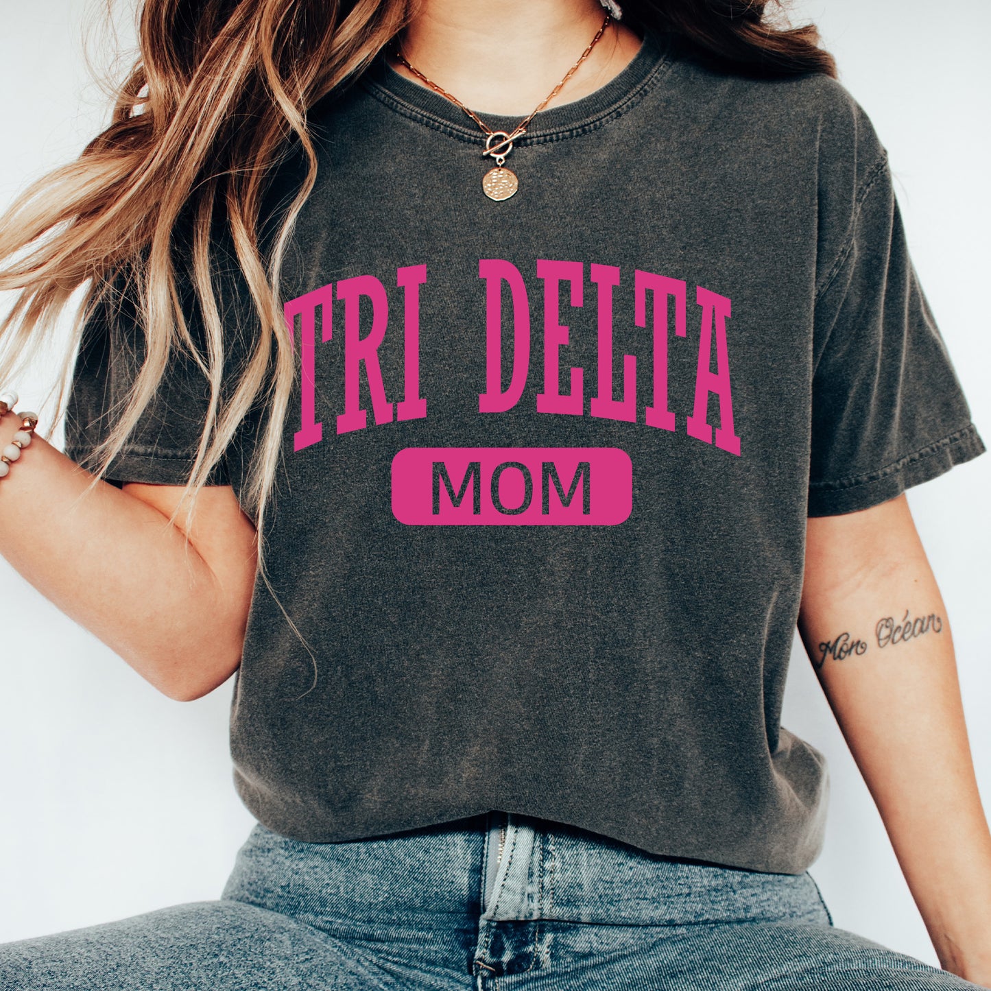 a woman wearing a t - shirt that says tri delta mom